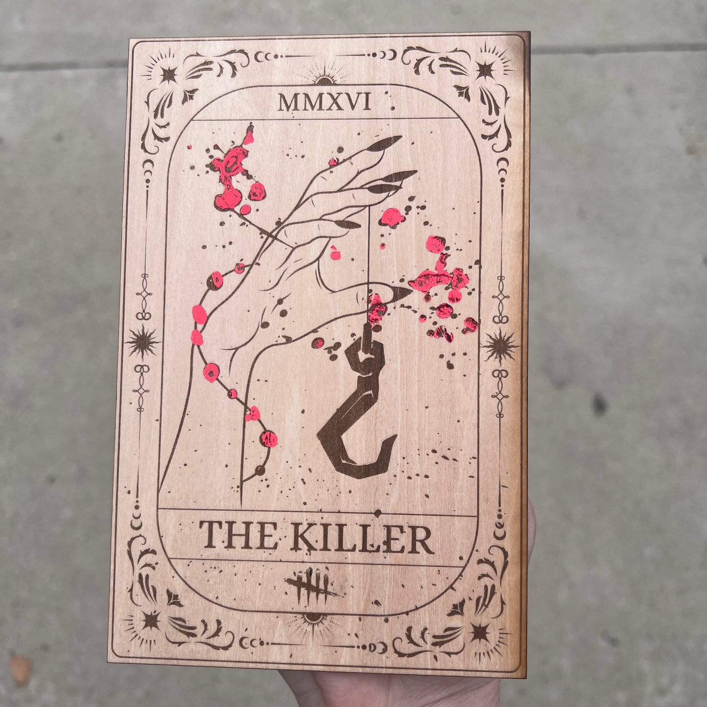 Laser engraved wooden tarot card featuring āThe Killerā inspired by Dead by Daylight with red foiled accents. Horror-themed gamer decor perfect for fans of spooky games and tarot.