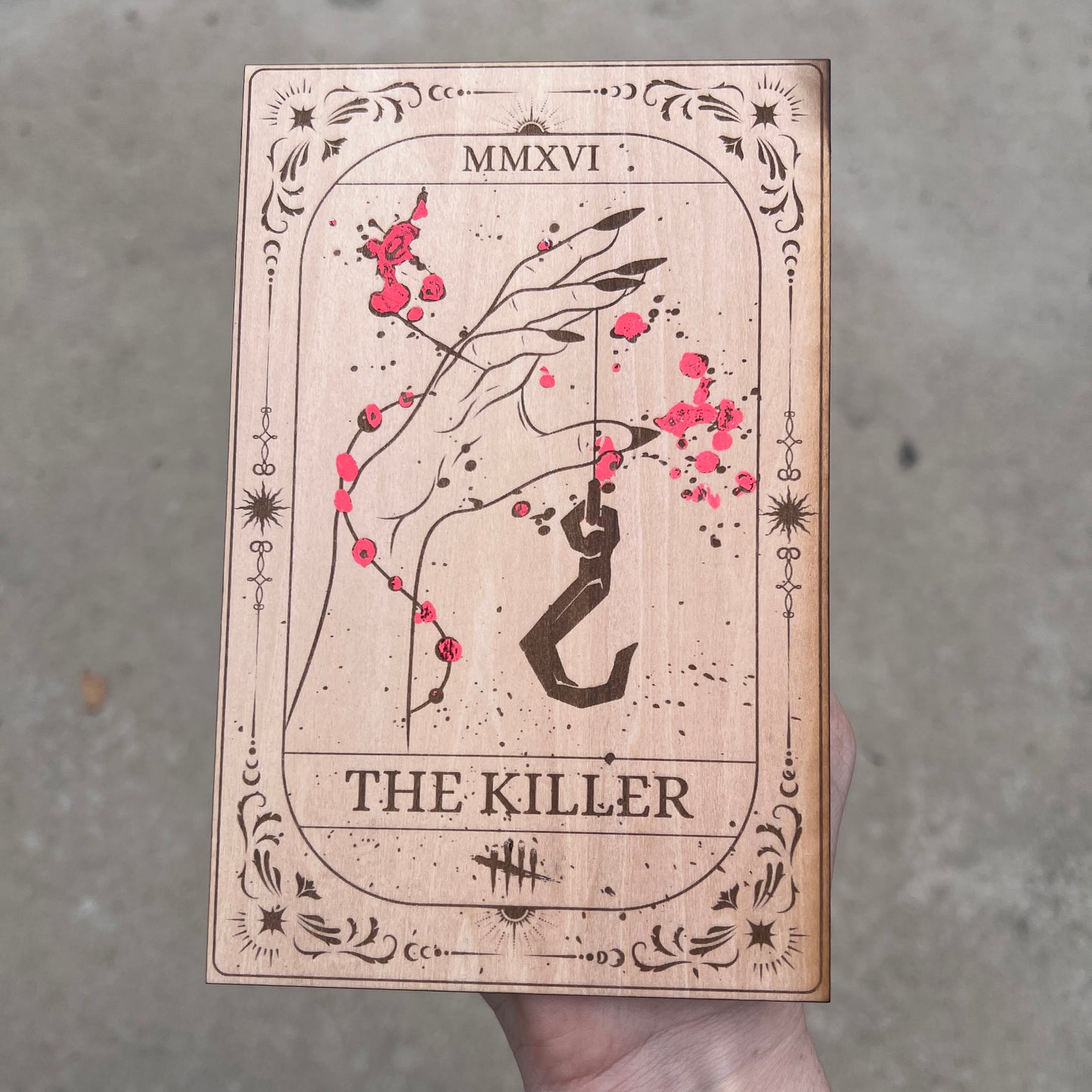 Laser engraved wooden tarot card featuring āThe Killerā inspired by Dead by Daylight with red foiled accents. Horror-themed gamer decor perfect for fans of spooky games and tarot.