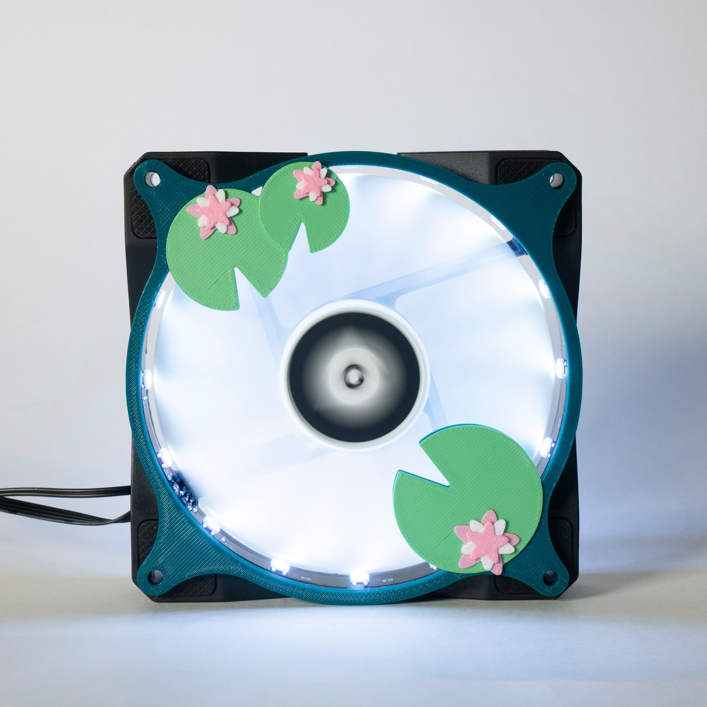 Adorable 3D printed PC fan grill with lily pad and lotus flower design. A cute nature-inspired fan cover perfect for cozy, aesthetic gaming setups.