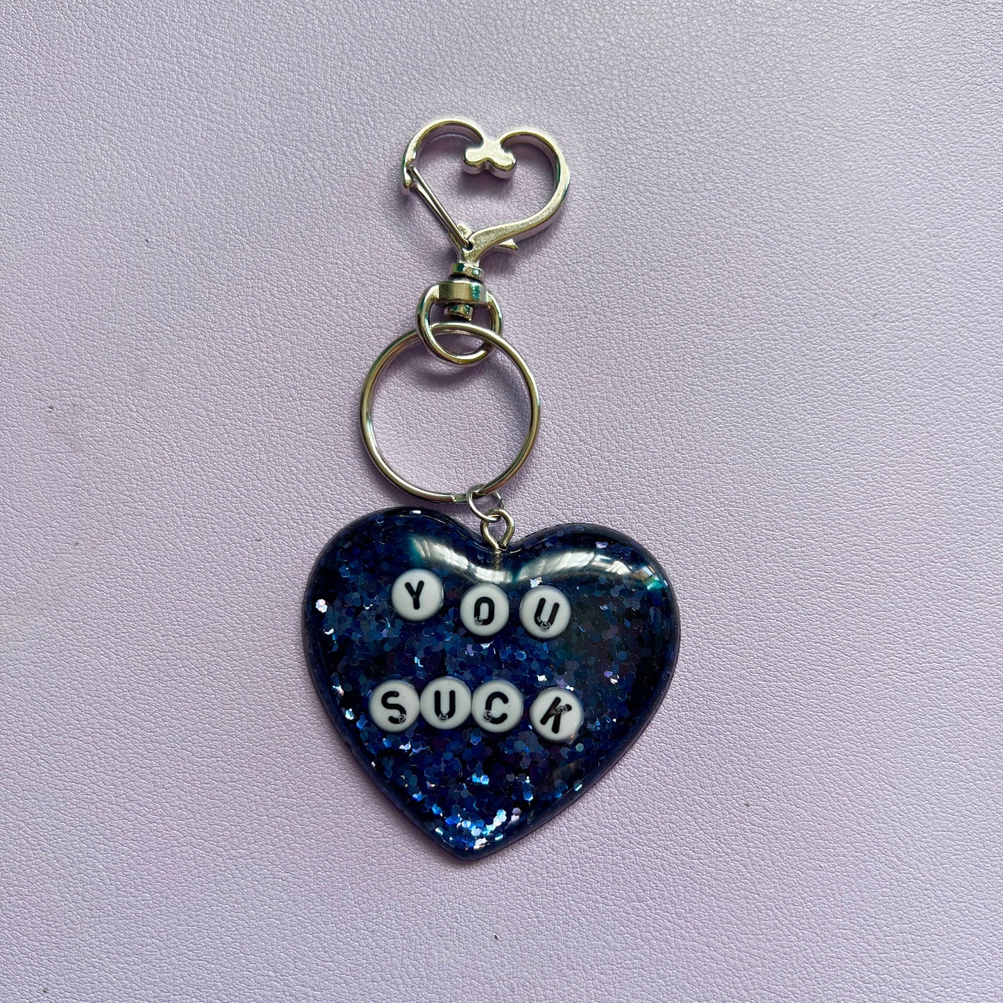 Customizable resin heart keychain with funny phrases. A fun, quirky gift for friends, this keychain can be personalized from a list of fun phrases. Perfect for adding personality to your keys or bags.