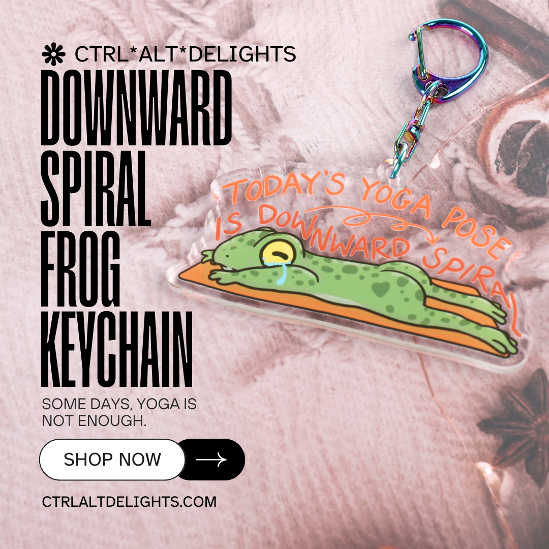 A clear acrylic keyring with a crying frog on a yoga mat, with the words today's yoga pose is downward spiral, in curling font above it. Attached to a blue iridescent claw clasp.