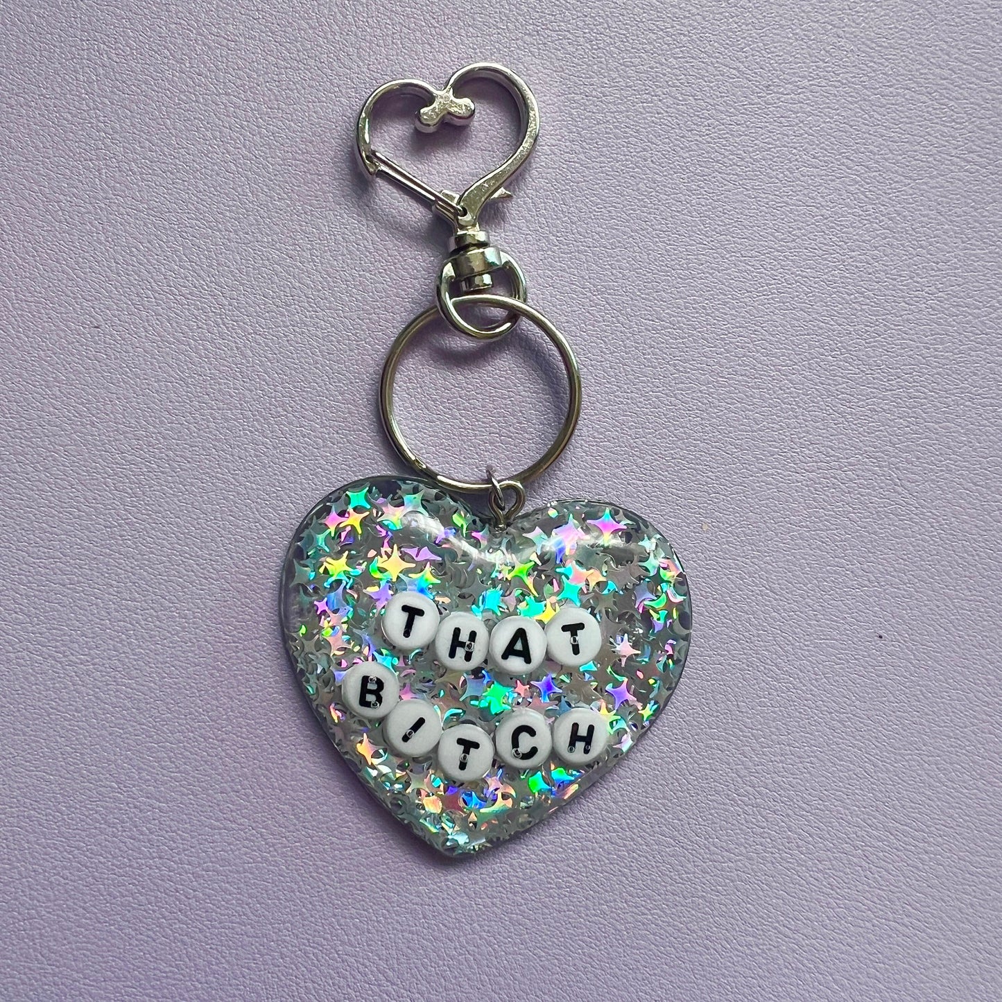 Customizable resin heart keychain with funny phrases. A fun, quirky gift for friends, this keychain can be personalized from a list of fun phrases. Perfect for adding personality to your keys or bags.