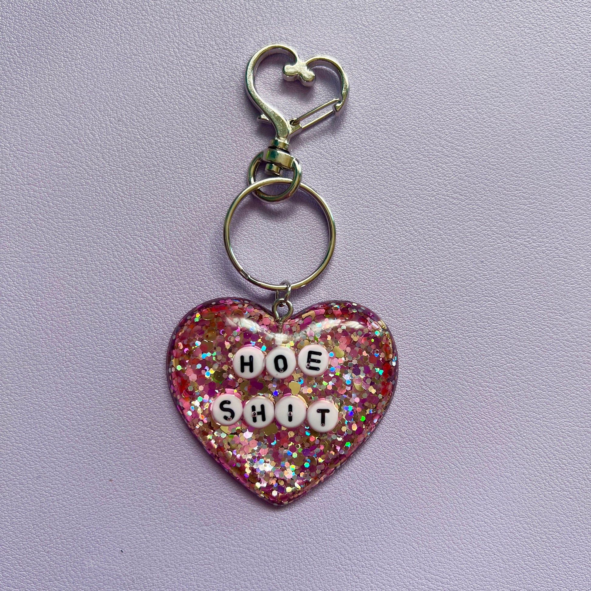 Customizable resin heart keychain with funny phrases. A fun, quirky gift for friends, this keychain can be personalized from a list of fun phrases. Perfect for adding personality to your keys or bags.