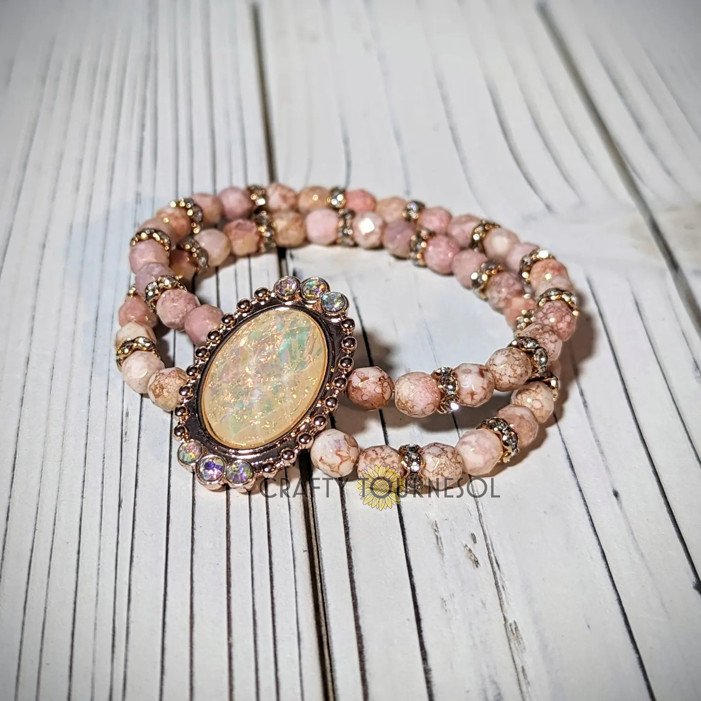 "Handcrafted pink Czech faceted gemstone beaded bracelet with vintage-inspired opalescent centerpiece and sparkling accents by Crafty Tournesol, perfect for adding a touch of elegance and charm to any boho or chic outfit."