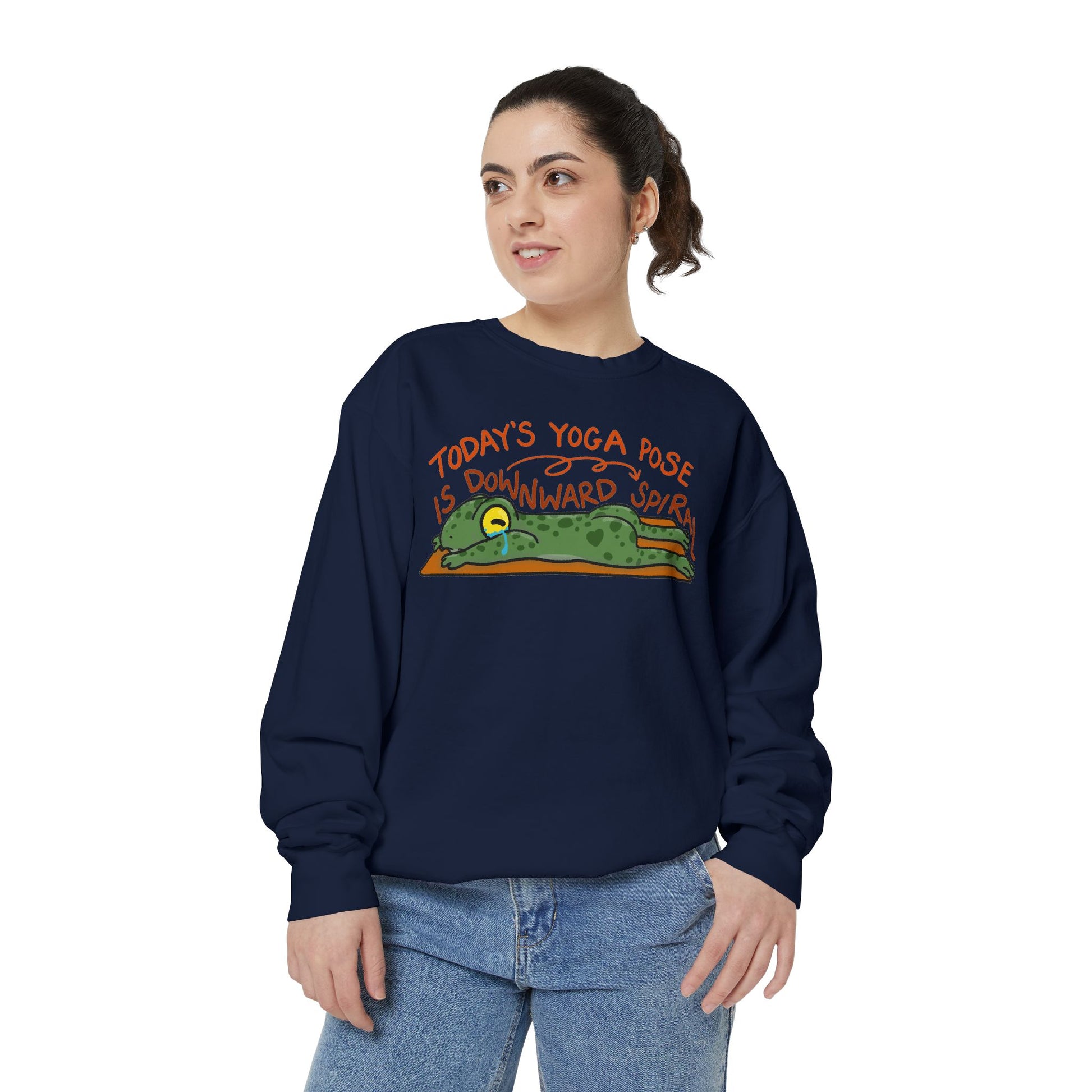 This sweatshirt features a cute, exhausted frog in a yoga pose with the text "Today's Yoga Pose is Downward Spiral." Perfect for yoga enthusiasts and those with a sense of humor.