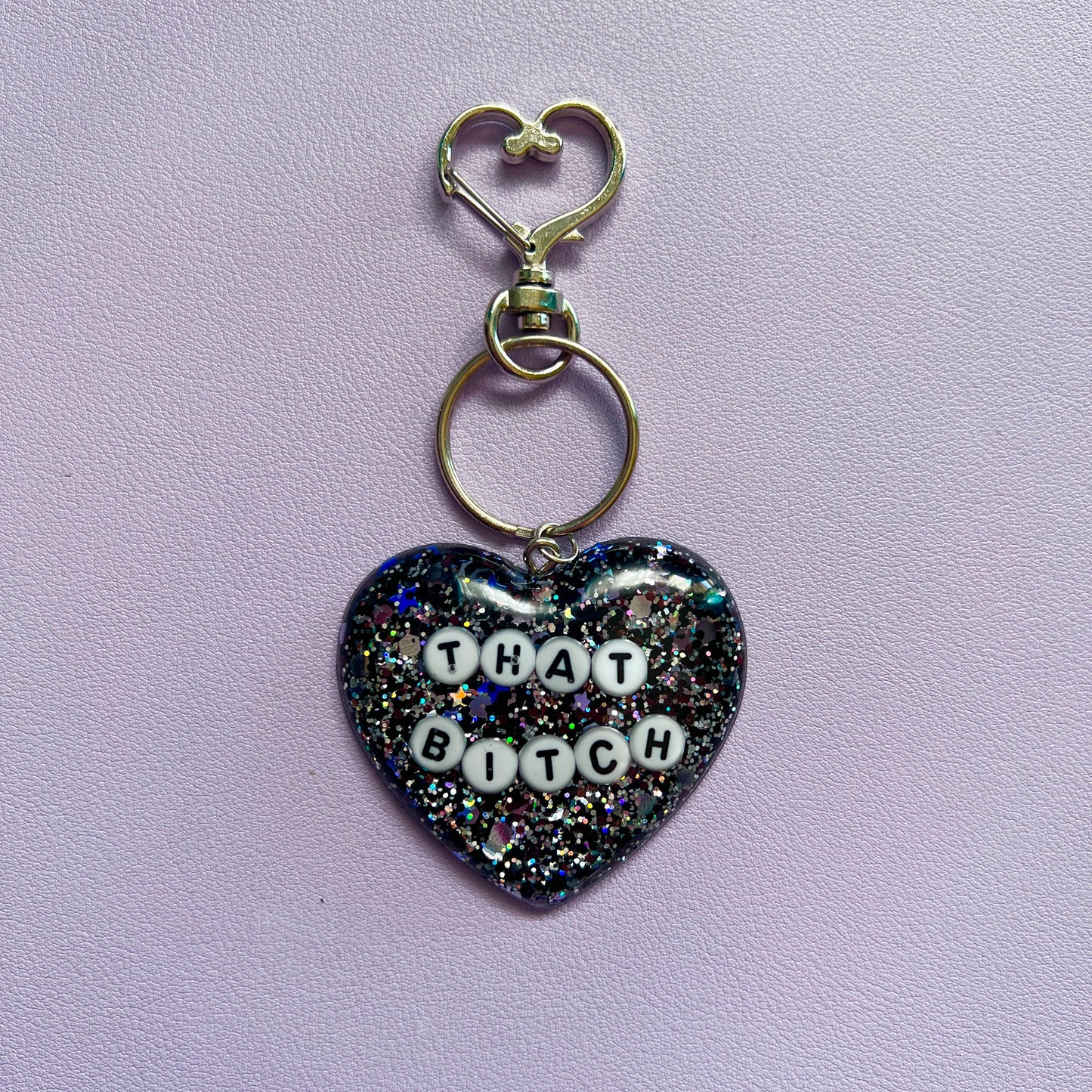 Customizable resin heart keychain with funny phrases. A fun, quirky gift for friends, this keychain can be personalized from a list of fun phrases. Perfect for adding personality to your keys or bags.