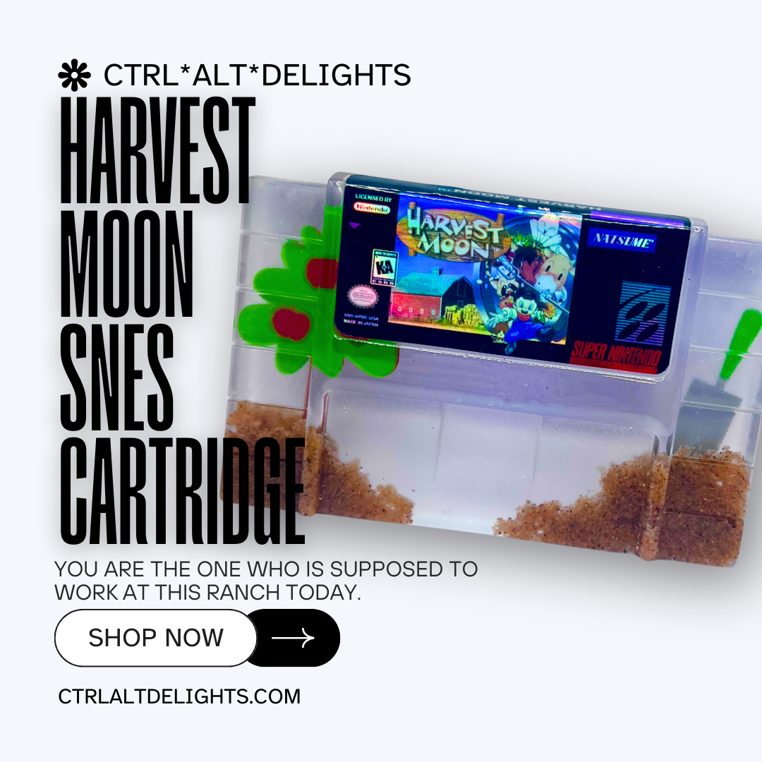 Custom resin art featuring a clear Super Nintendo game cartridge of Harvest Moon filled with decorative sand and tiny plant accents. Perfect as a nostalgic, geek-inspired desk or shelf display for retro gaming enthusiasts.