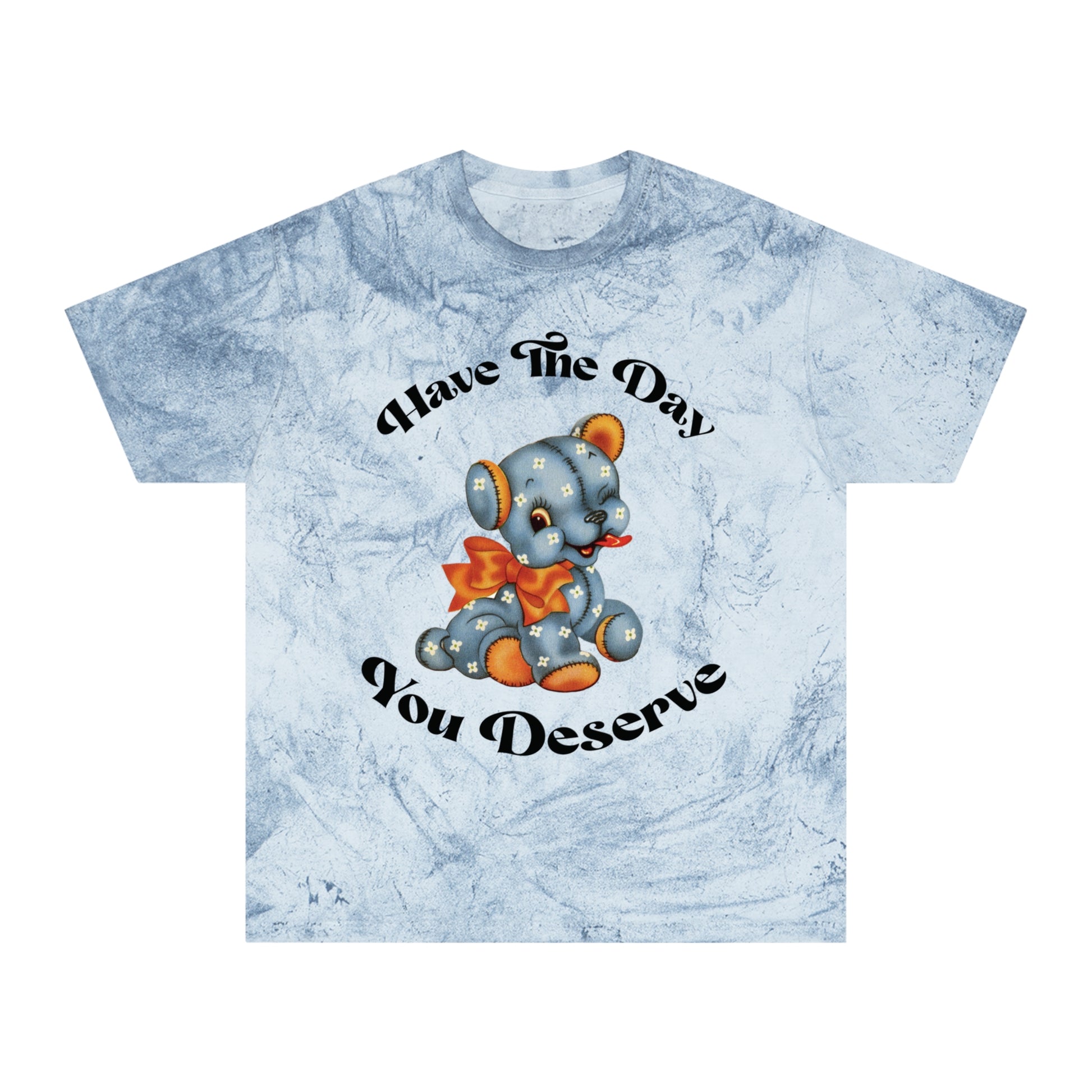 T-shirt with a cute plush bear design in shades of blue, wearing a red bow, accompanied by the playful phrase, Have the Day You Deserve. Casual and relaxed fit for an effortlessly cool look. Available in Blue, Gray, and Citrine.