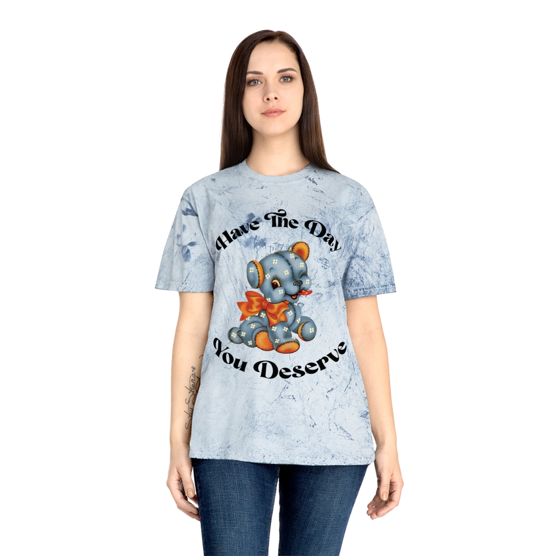 T-shirt with a cute plush bear design in shades of blue, wearing a red bow, accompanied by the playful phrase, Have the Day You Deserve. Casual and relaxed fit for an effortlessly cool look. Available in Blue, Gray, and Citrine.