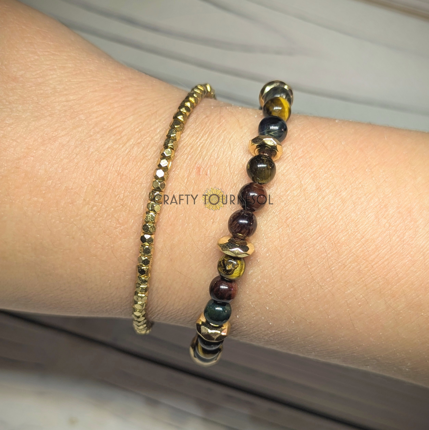 "Stylish bracelet set on wrist featuring tiger's eye and gold beads, accompanied by coordinating bracelet with gold beads, offering an earthy yet luxurious look. Perfect accessory for adding elegance and a touch of nature-inspired charm to any outfit."