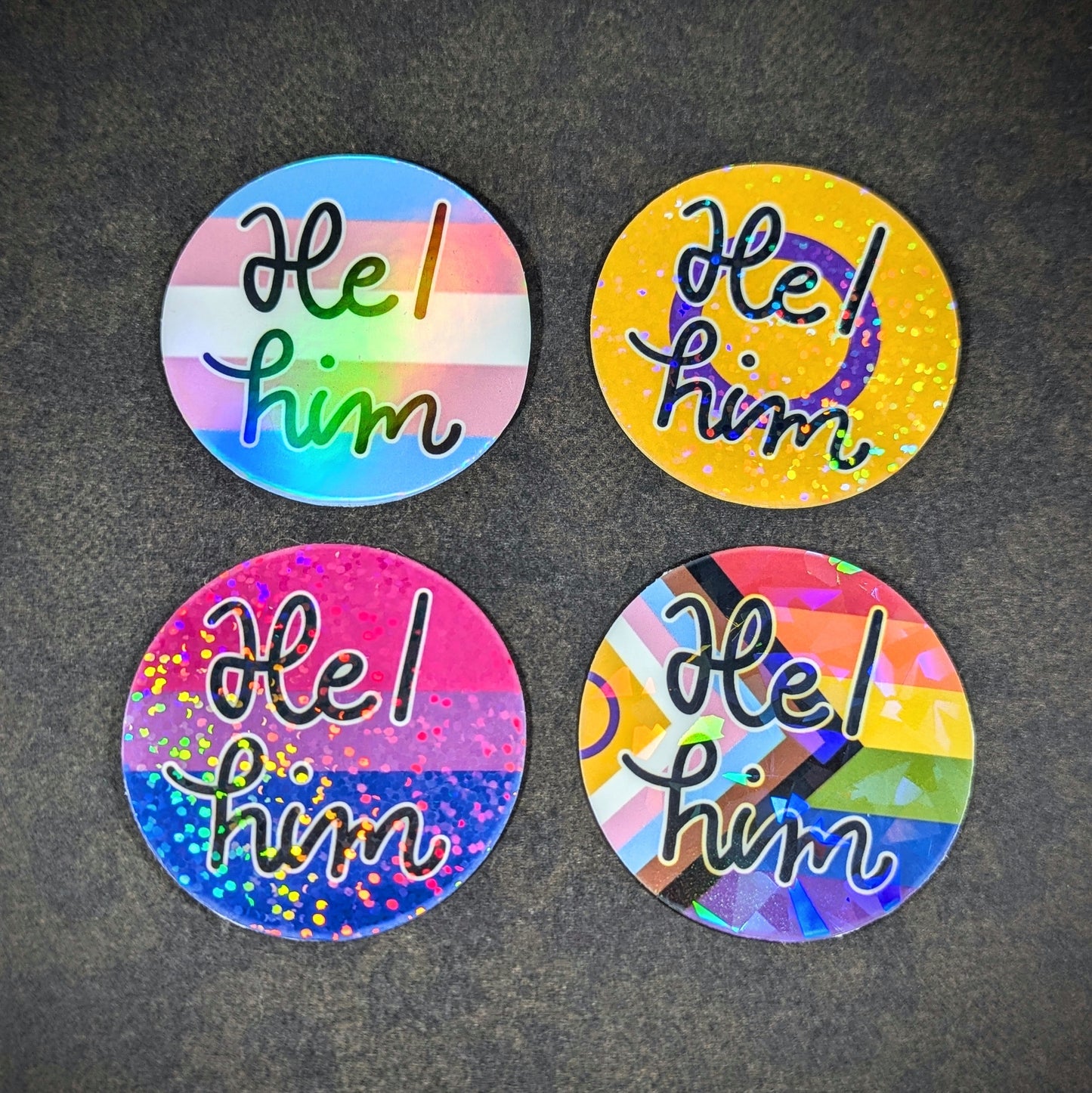 "Round holographic pronoun stickers featuring 'He him' in various LGBTQ+ pride flag designs, perfect for expressing gender identity and inclusivity on laptops, water bottles, and notebooks."