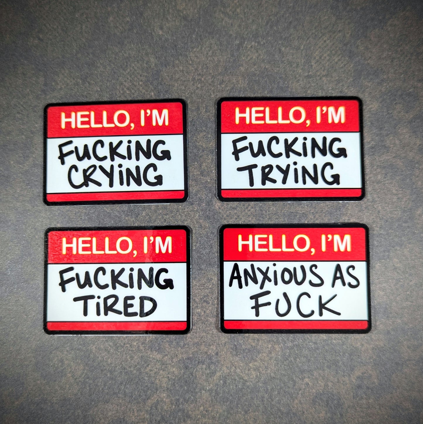 "Set of humorous 'Hello, I'm' stickers with phrases like 'f***ing crying,' 'f***ing trying,' 'f***ing tired,' and 'anxious as f***.' Perfect for expressing moods with edgy, relatable humor."