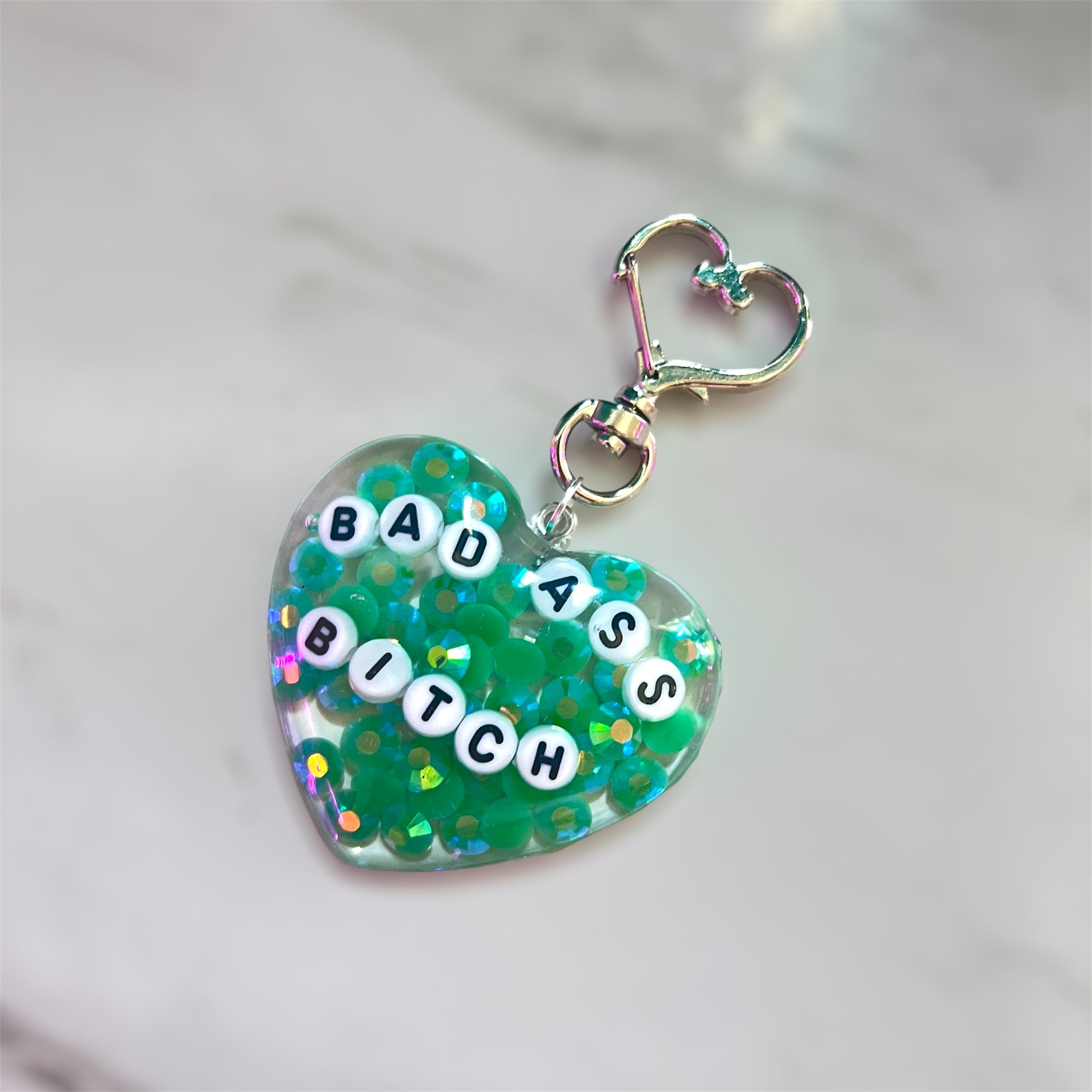 Customizable resin heart keychain with funny phrases. A fun, quirky gift for friends, this keychain can be personalized from a list of fun phrases. Perfect for adding personality to your keys or bags.