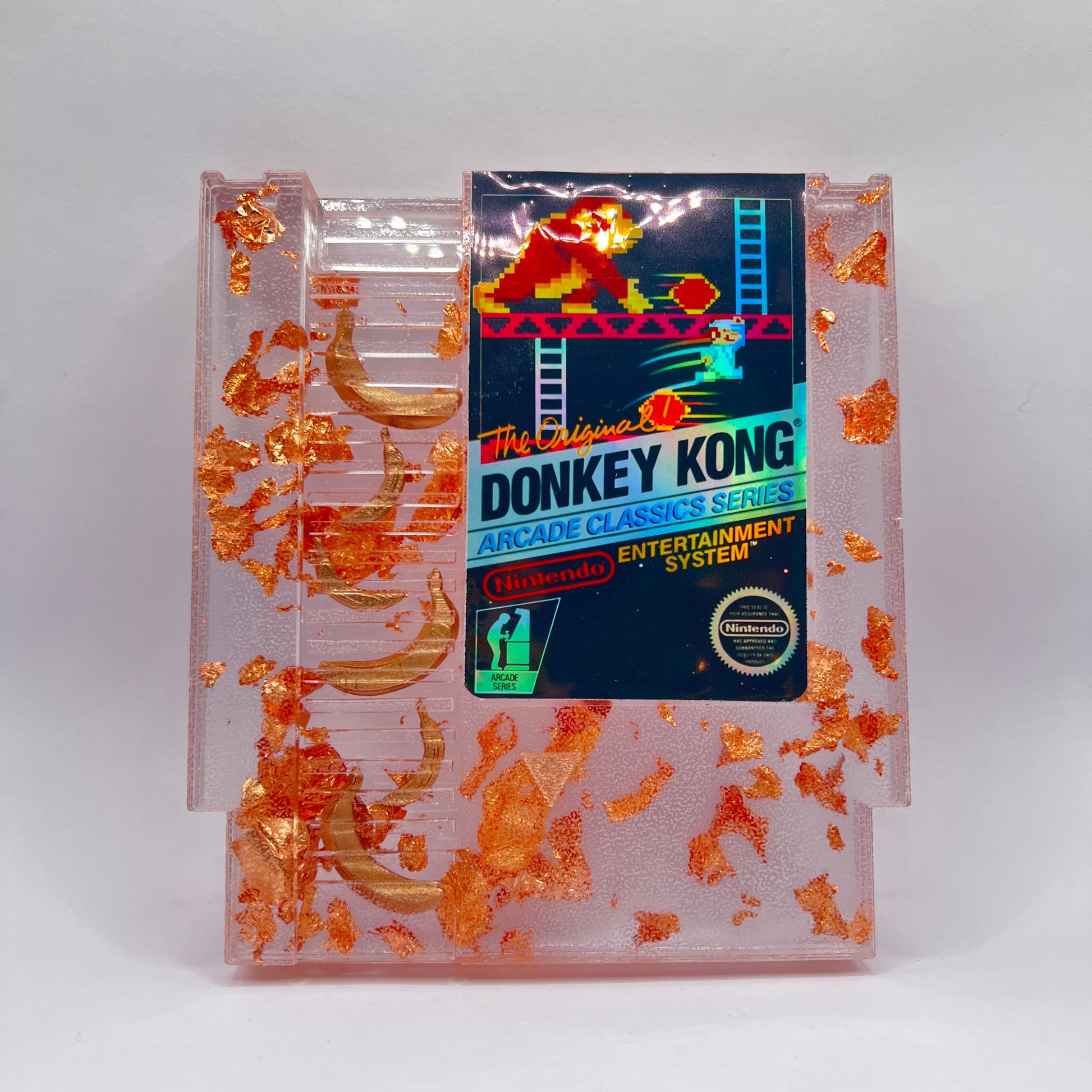 Handmade Donkey Kong NES cartridge art featuring gold bananas and copper leaf accents. Perfect retro gaming gift or unique game room decor.