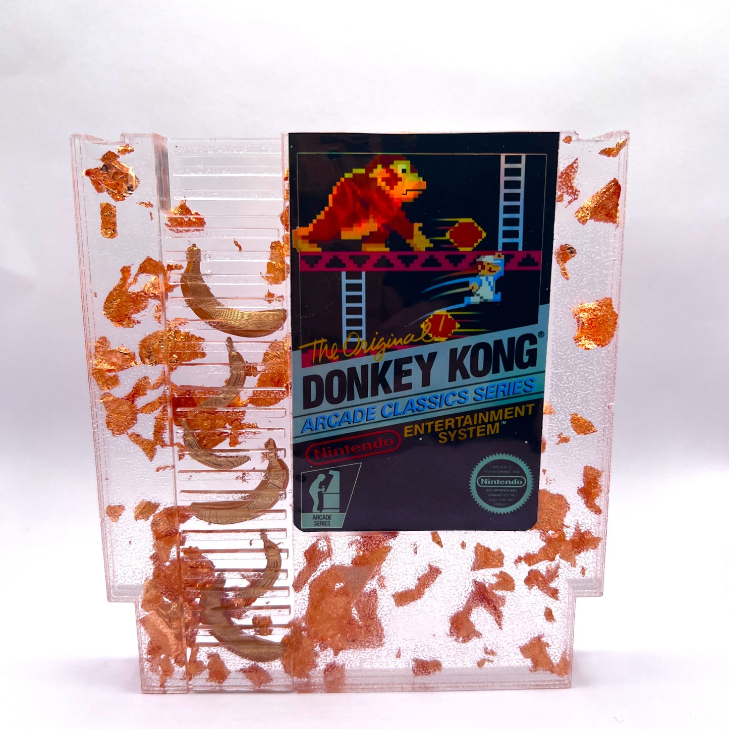 Handmade Donkey Kong NES cartridge art featuring gold bananas and copper leaf accents. Perfect retro gaming gift or unique game room decor.