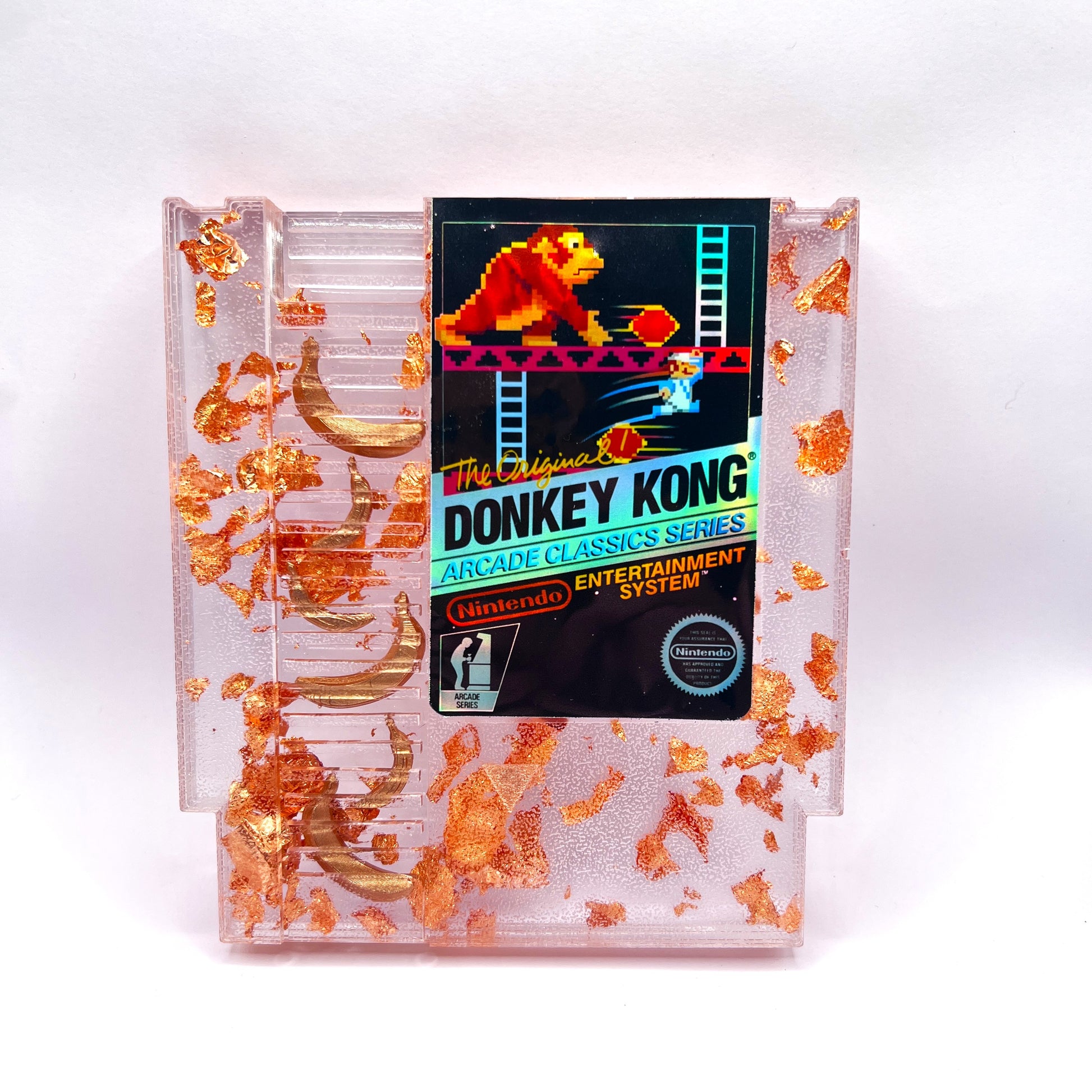 Handmade Donkey Kong NES cartridge art featuring gold bananas and copper leaf accents. Perfect retro gaming gift or unique game room decor.