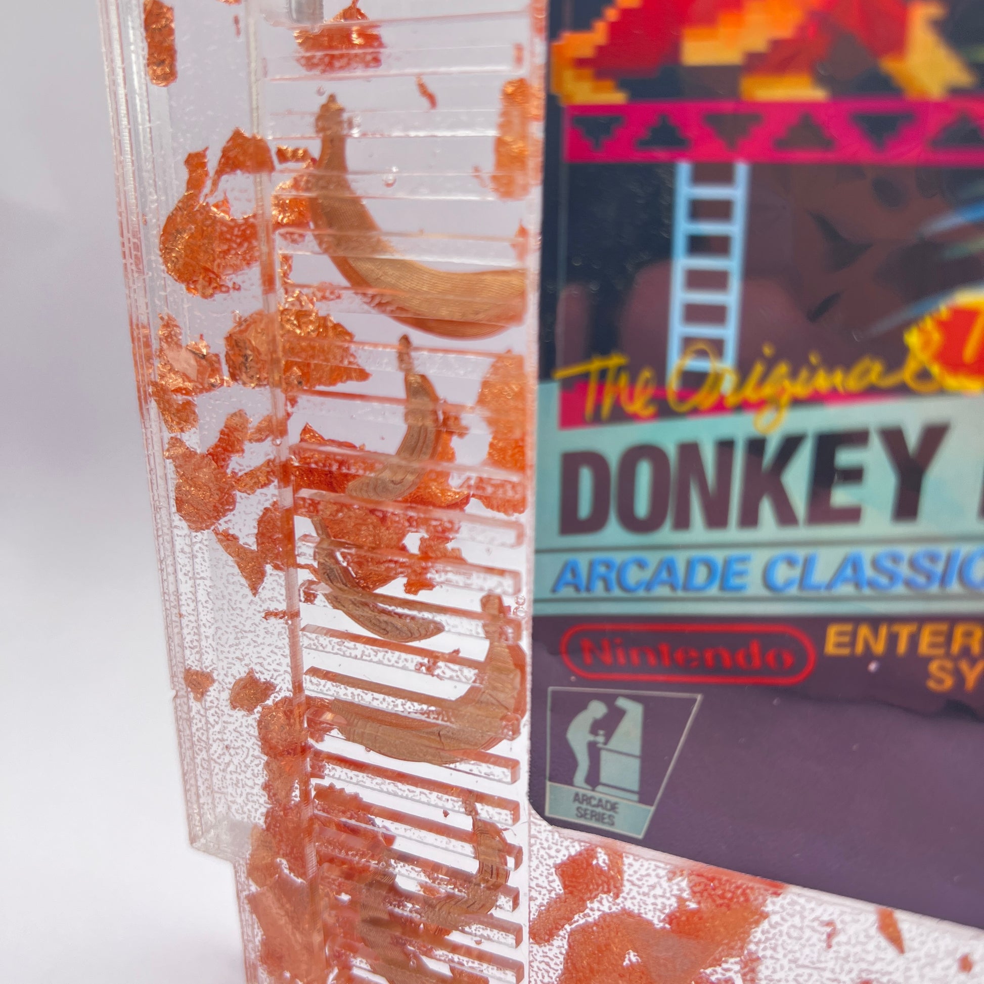 Handmade Donkey Kong NES cartridge art featuring gold bananas and copper leaf accents. Perfect retro gaming gift or unique game room decor.