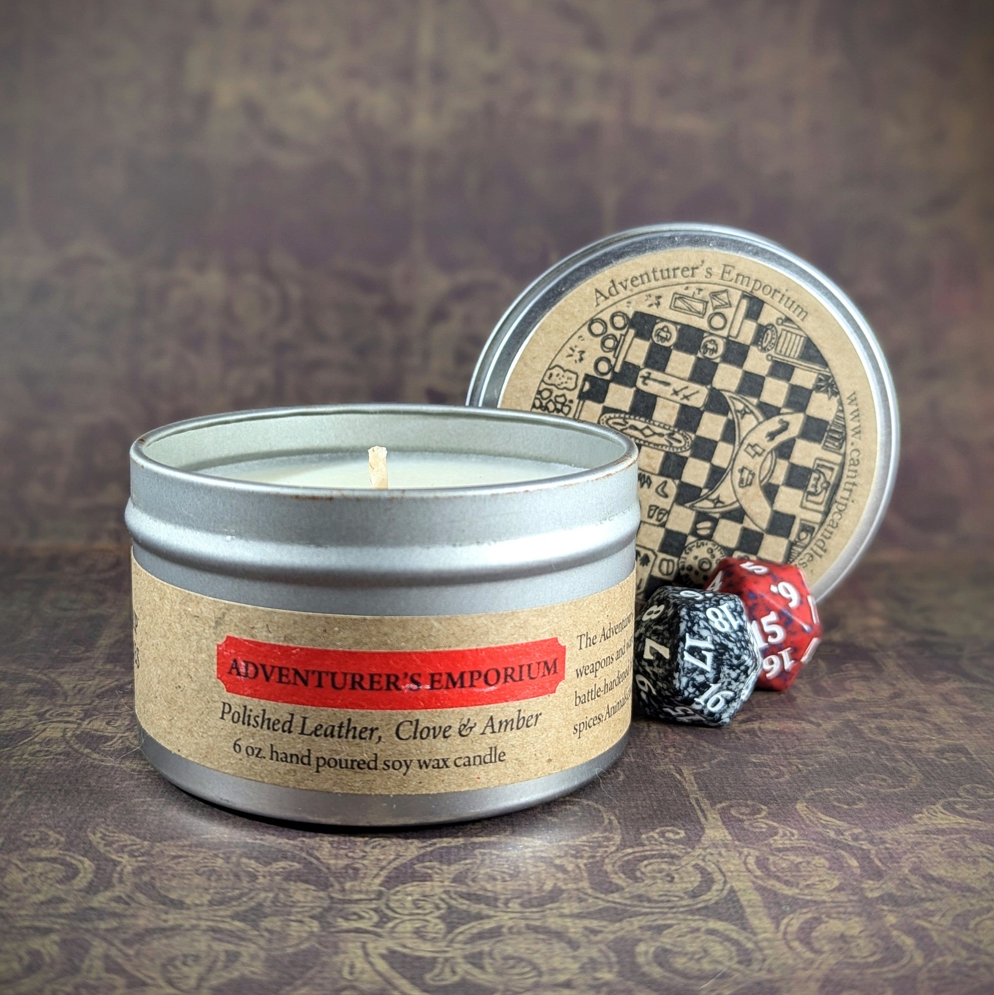 "Adventurer's Emporium 6 oz soy wax candle tin in Polished Leather, Clove & Amber scent, staged with with RPG dice, ideal for gamers seeking an immersive, medieval-inspired ambiance for tabletop sessions or cozy home decor."