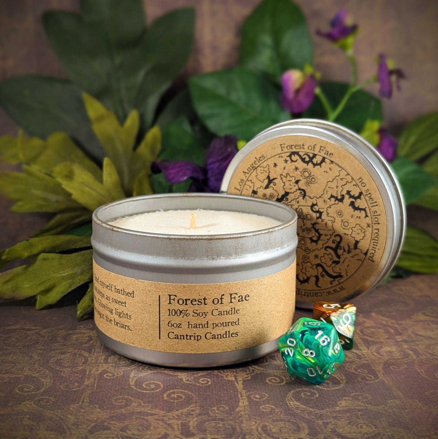 "Forest of Fae 6 oz soy wax candle tin with enchanting scents of jasmine, neroli, tomato leaf, and amber, staged with RPG dice and floral decor, perfect for gamers and fantasy lovers looking to bring a touch of mystical forest ambiance into their space."