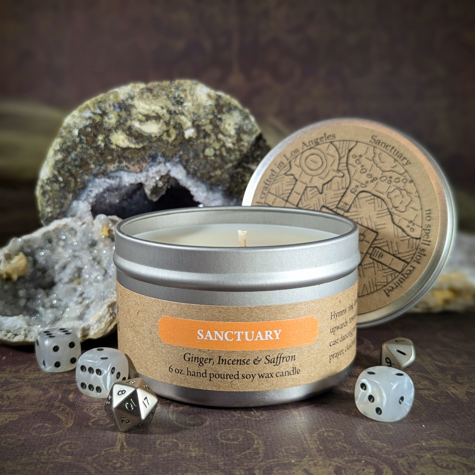 Alt text: "Sanctuary 6 oz soy wax candle tin in Ginger, Incense & Saffron scent with RPG dice and geode decor, perfect for creating a calming atmosphere for gamers or adding a mystical touch to any relaxation space."