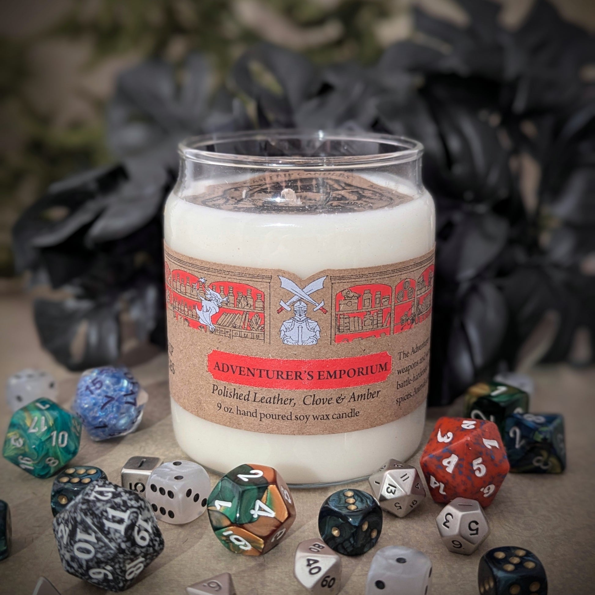 "Adventurer’s Emporium candle by Cantrip Candles, 9 oz soy wax with scents of polished leather, clove, and amber. Staged with RPG dice. Perfect for D&D fans seeking an immersive tabletop experience."