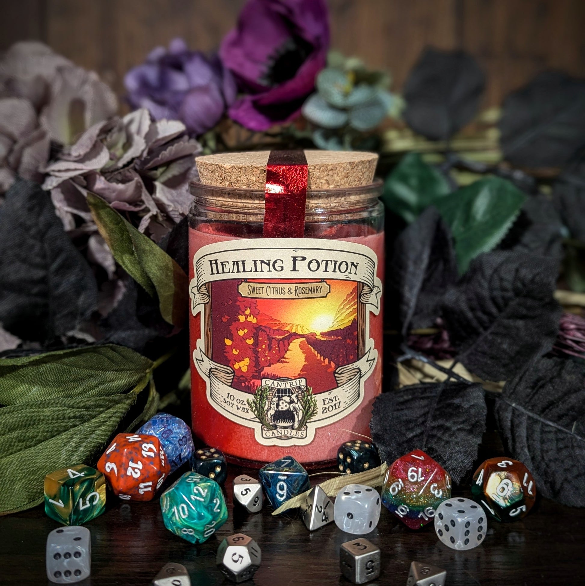 "Healing Potion candle by Cantrip Candles with sweet citrus and rosemary scent. RPG-inspired décor surrounded by dice, perfect for tabletop gamers and fantasy lovers seeking immersive ambiance."