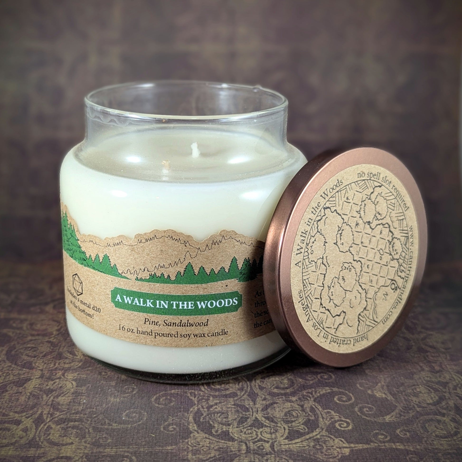 "A Walk in the Woods candle by Cantrip Candles, 16 oz soy wax, pine and sandalwood scent. Hand-poured with detailed map design on lid, perfect for nature lovers and cozy ambiance seekers."