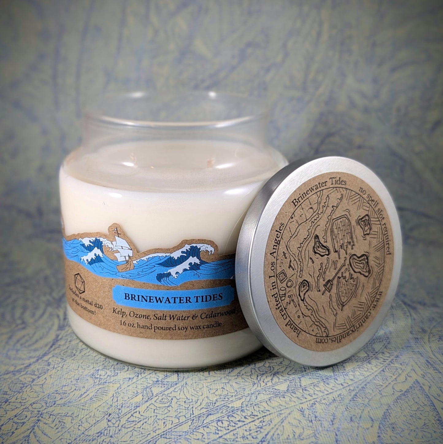 "Brinewater Tides candle by Cantrip Candles, 16 oz soy wax blend with kelp, ozone, saltwater, and cedarwood scent. Nautical map lid, perfect for ocean-themed RPG sessions or adding coastal ambiance to any room."