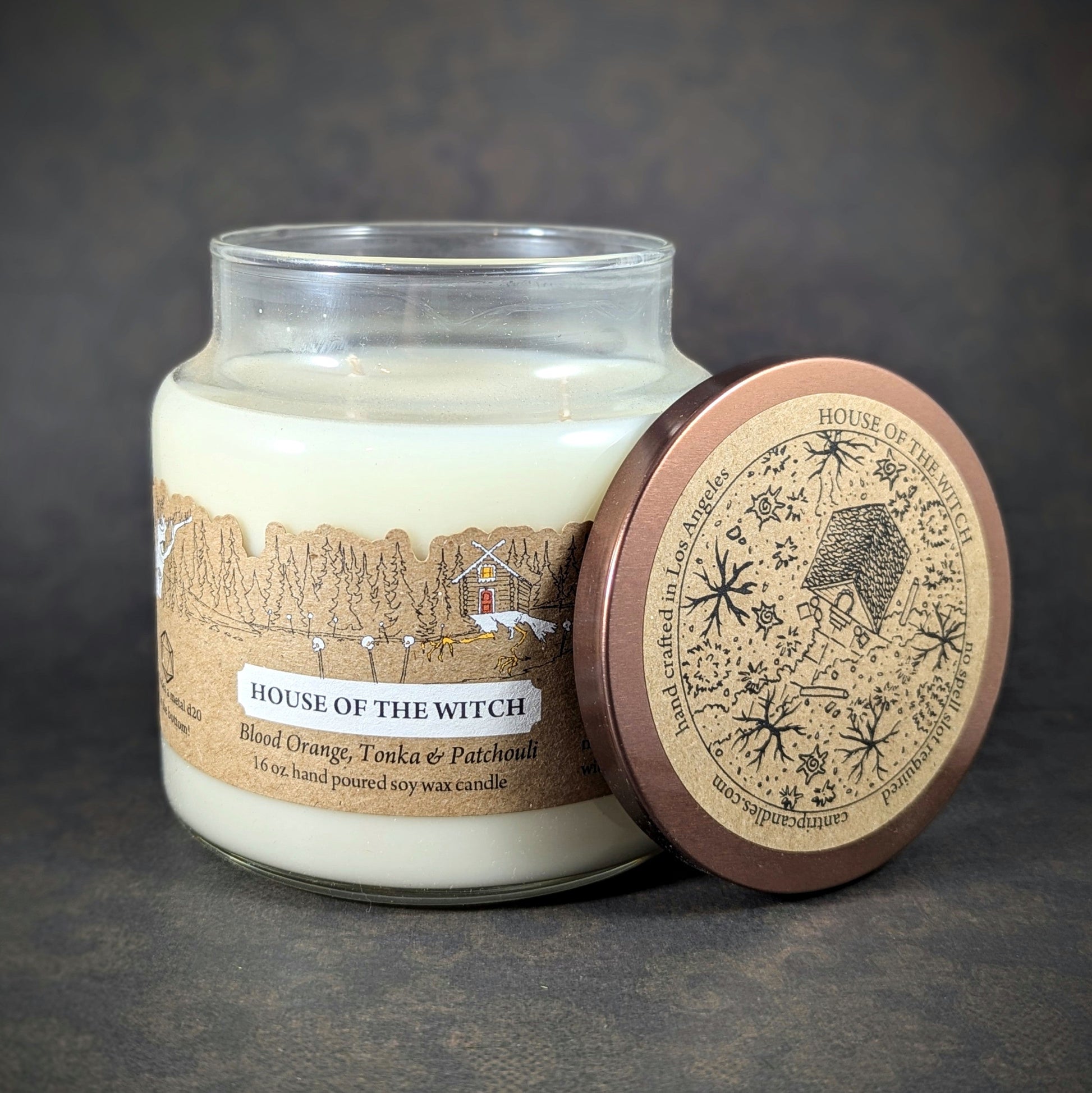 "House of the Witch candle by Cantrip Candles, 16 oz soy wax with notes of blood orange, tonka, and patchouli. Comes with a witchy map lid, perfect for enhancing the ambiance of fantasy and magical settings."