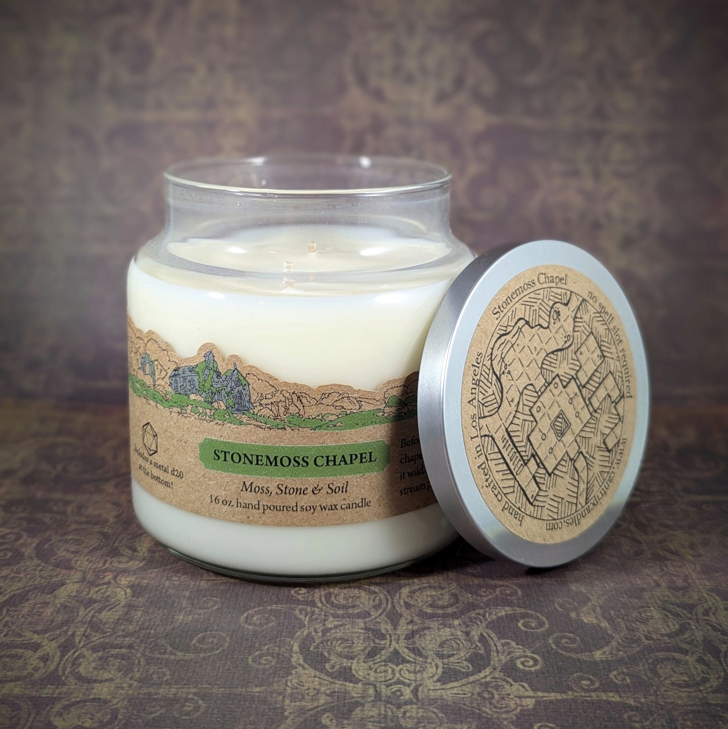 "Stonemoss Chapel candle by Cantrip Candles, 16 oz soy wax with earthy scents of moss, stone, and soil. Features detailed chapel illustration on lid, perfect for creating a grounding, nature-inspired ambiance."