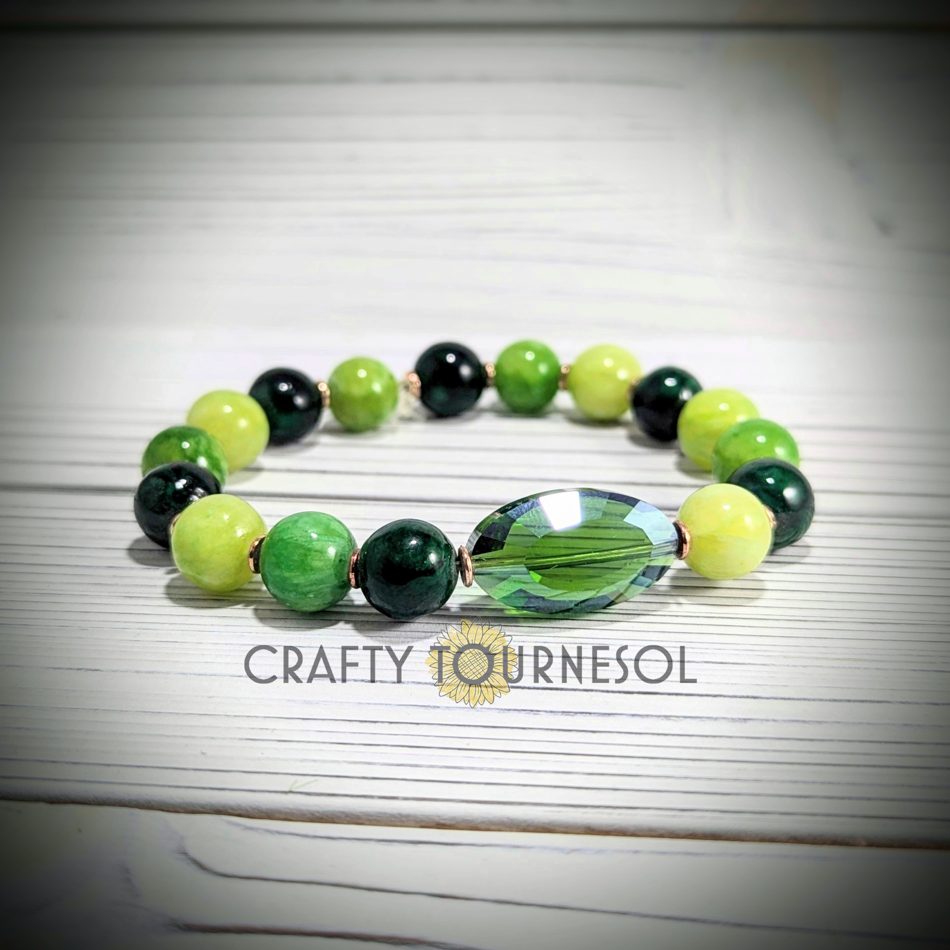 "Elegant green quartz gemstone bracelet featuring varied green beads, gold accent spacer beads, and a large faceted centerpiece. Perfect for nature lovers and those seeking a unique, earthy accessory to add color and charm to any look."