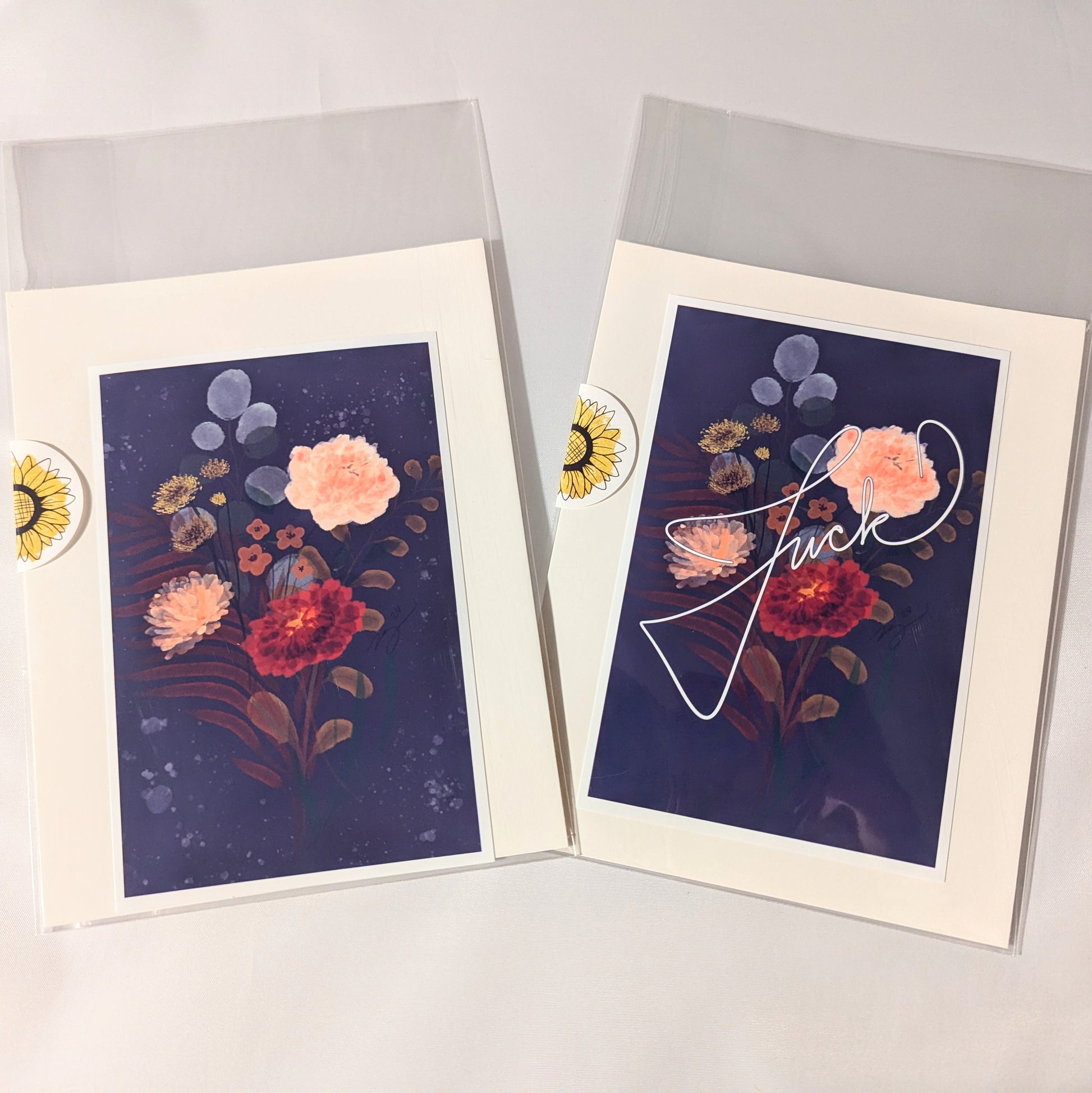 "Set of two vintage-inspired floral art prints, one with elegant script text, packaged in protective sleeves with sunflower stickers. Perfect for adding botanical charm to home decor or gifting."