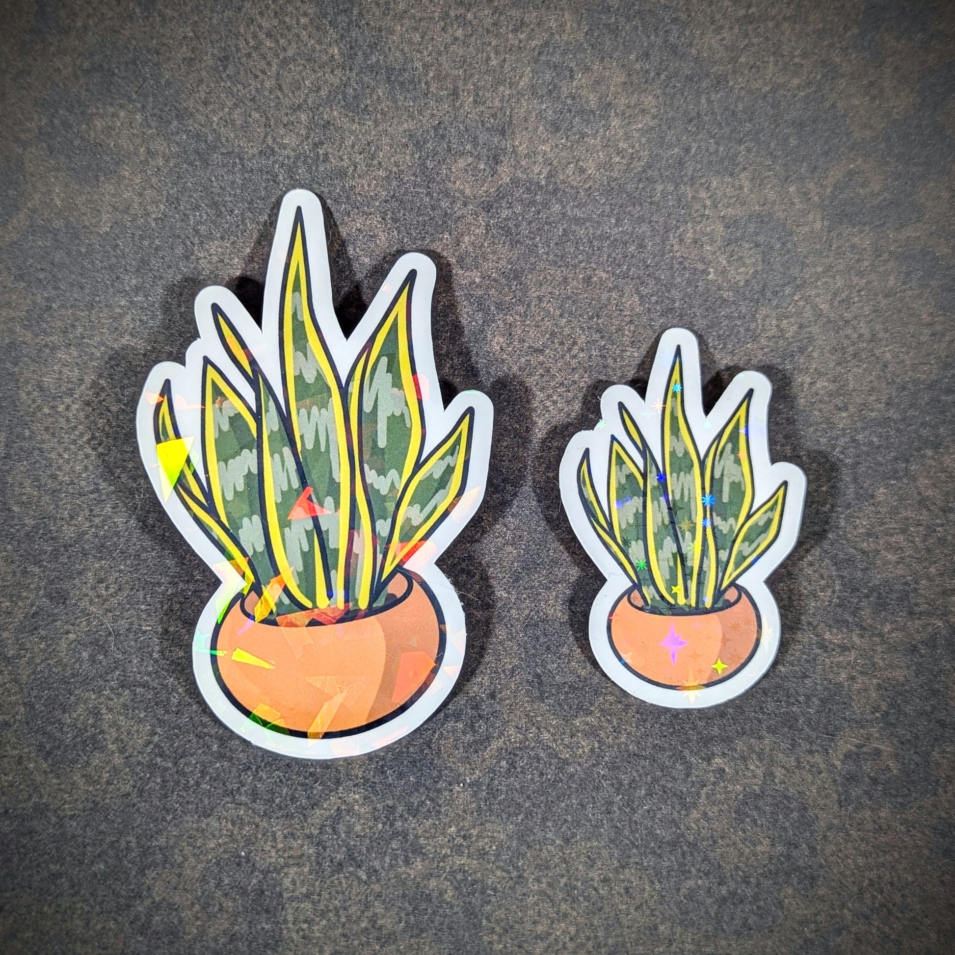 "Pair of holographic sansevieria (snake plant) stickers in terracotta pots, featuring vibrant green leaves with sparkling accents. Perfect for plant lovers adding botanical charm to laptops, journals, or decor."