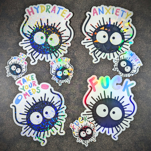 "Set of holographic soot sprite stickers with phrases like 'Hydrate,' 'Anxiety,' 'Take Your Meds,' and 'F***.' Perfect for anime fans and mental health advocates adding a playful, sparkly touch to personal items."