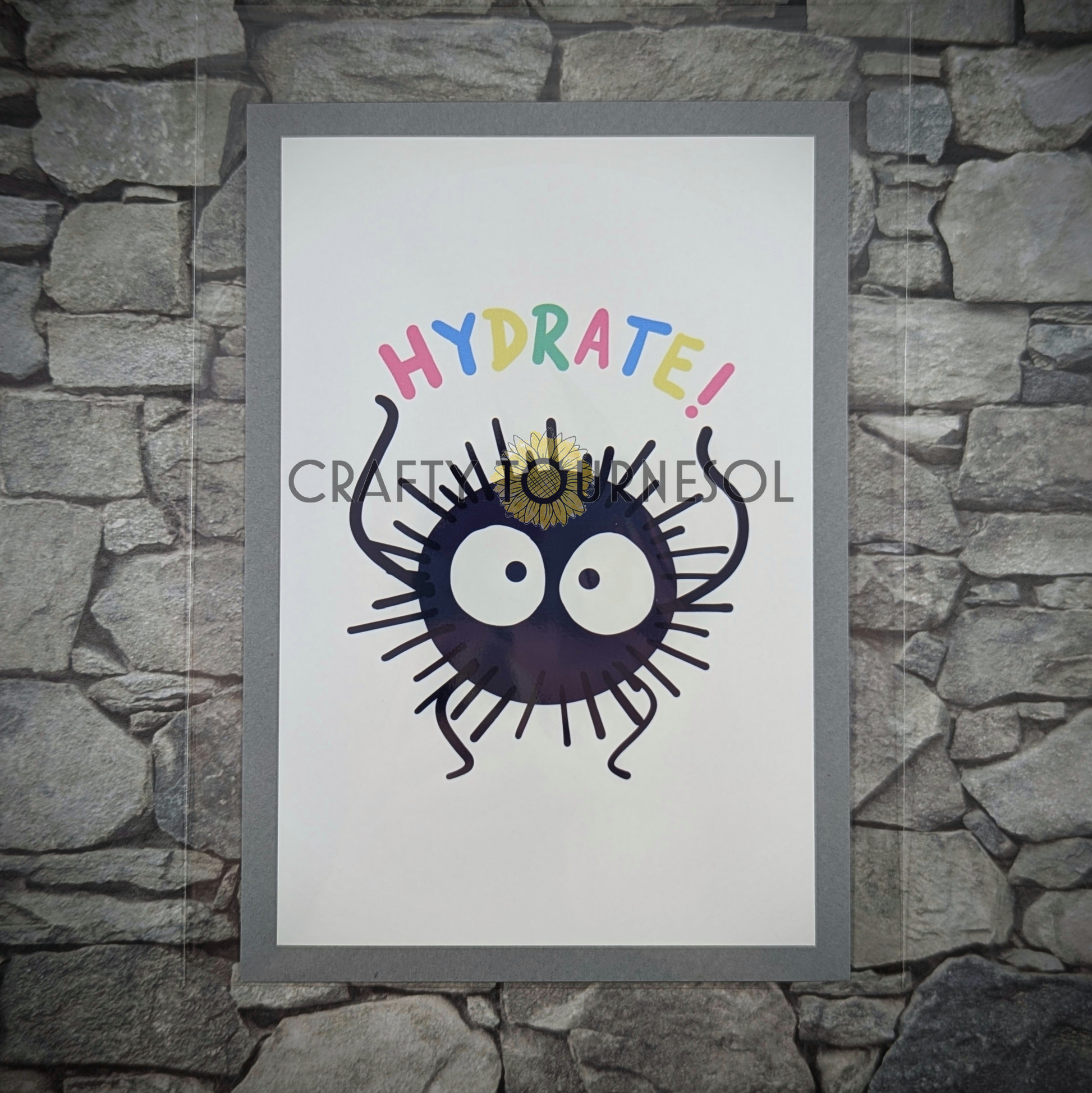 "4"x6" fanart print of soot sprite, holding 'Hydrate!' text in playful colors. Perfect for anime fans and mental health advocates adding a playful, geeky touch to favorite space."