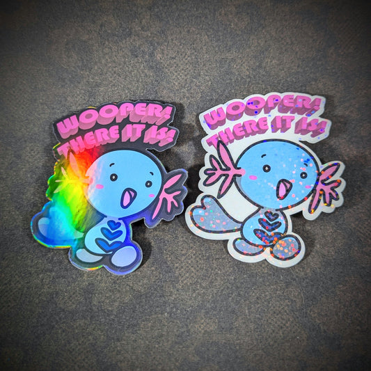 "Holographic 'Wooper! There It Is' stickers featuring a cute blue Wooper from Pokemon, playing off of '90s song hit 'Whoomp! (There It Is)." Perfect for fans of gaming and collectibles. Great for decorating laptops, water bottles, and more."