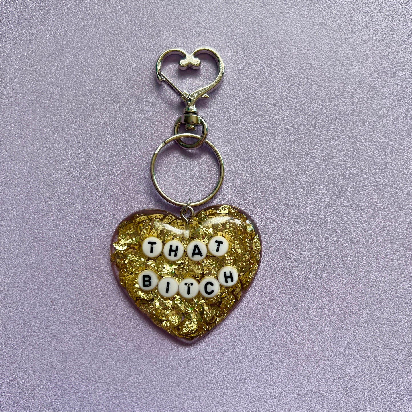 Customizable resin heart keychain with funny phrases. A fun, quirky gift for friends, this keychain can be personalized from a list of fun phrases. Perfect for adding personality to your keys or bags.