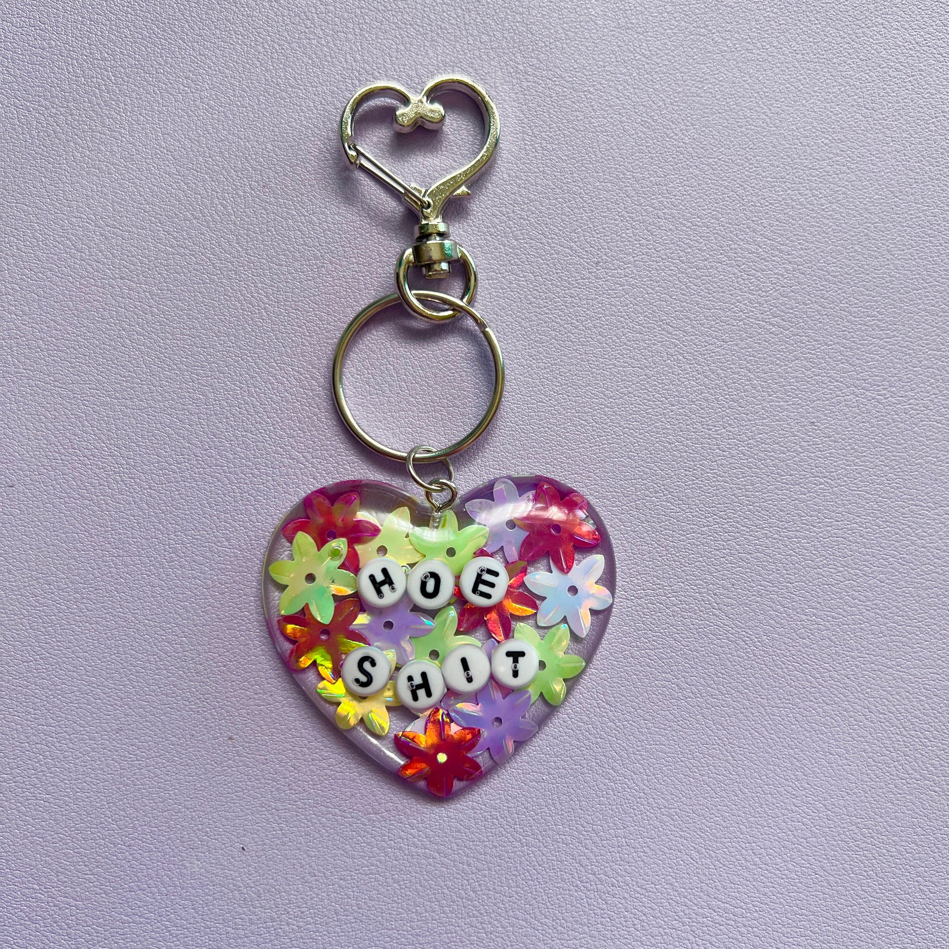 Customizable resin heart keychain with funny phrases. A fun, quirky gift for friends, this keychain can be personalized from a list of fun phrases. Perfect for adding personality to your keys or bags.