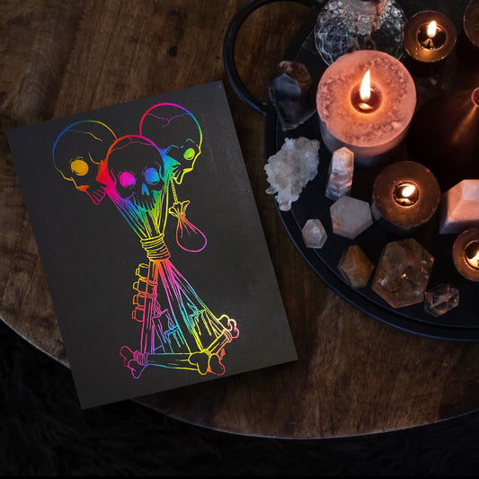 Hand-foiled Dead by Daylight totem artwork featuring three rainbow-colored skulls tied with candles and bones on black cardstock. This custom, vibrant totem design brings a unique twist to iconic game imagery, perfect for horror and gaming fans.