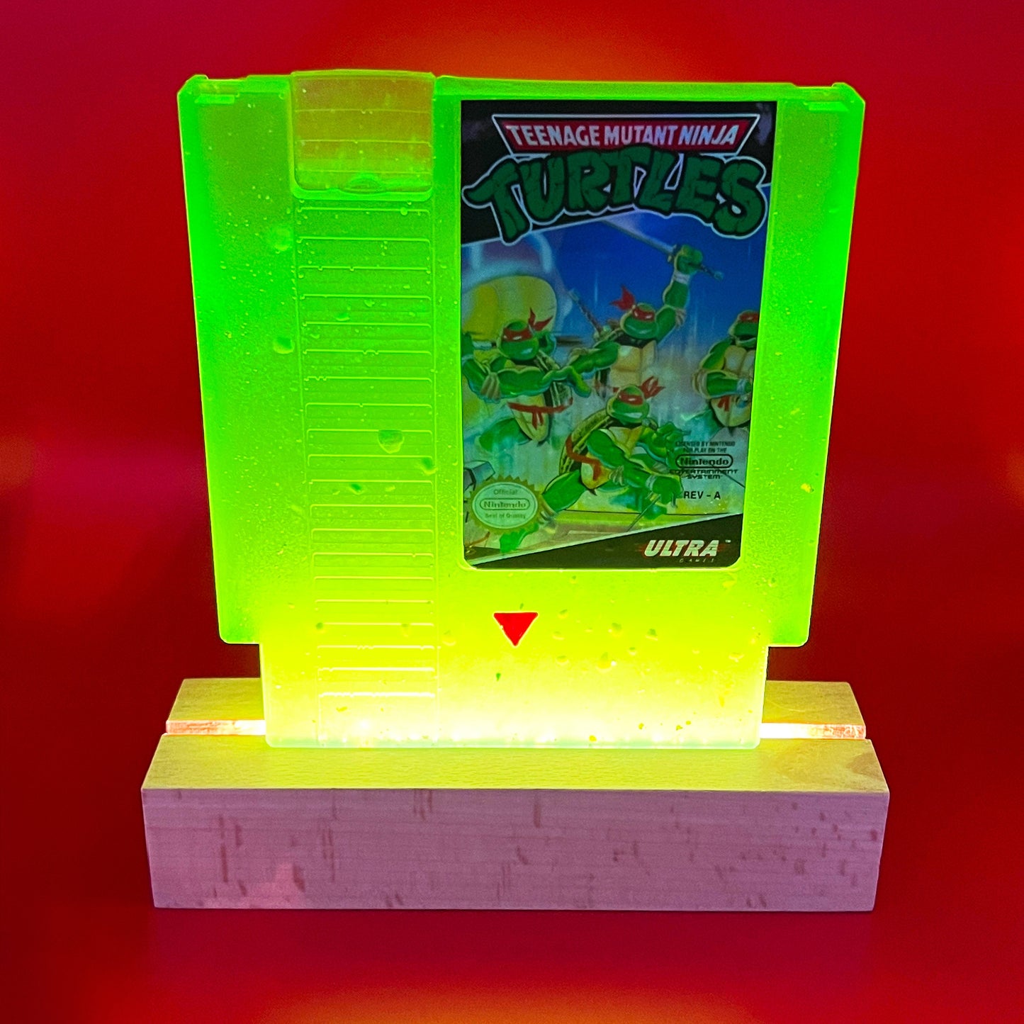 This glowing Teenage Mutant Ninja Turtles NES cartridge is a retro, geeky collectible display. Handmade with glowing elements, it's perfect for nostalgic gamers and TMNT fans as a unique gift or decor.