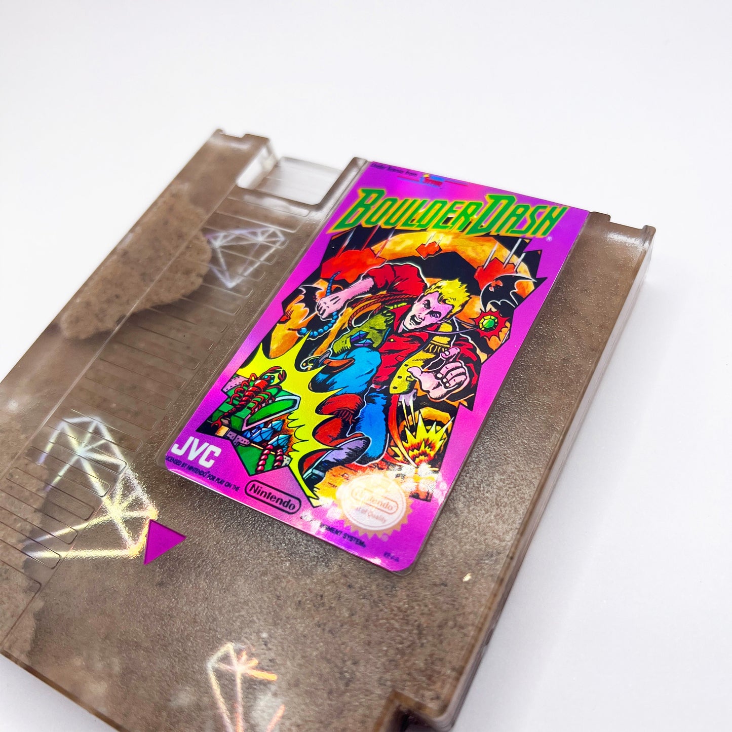 Handmade Boulder Dash NES cartridge art featuring intricate sand and diamond designs on a transparent casing. A perfect gift for retro gaming enthusiasts.