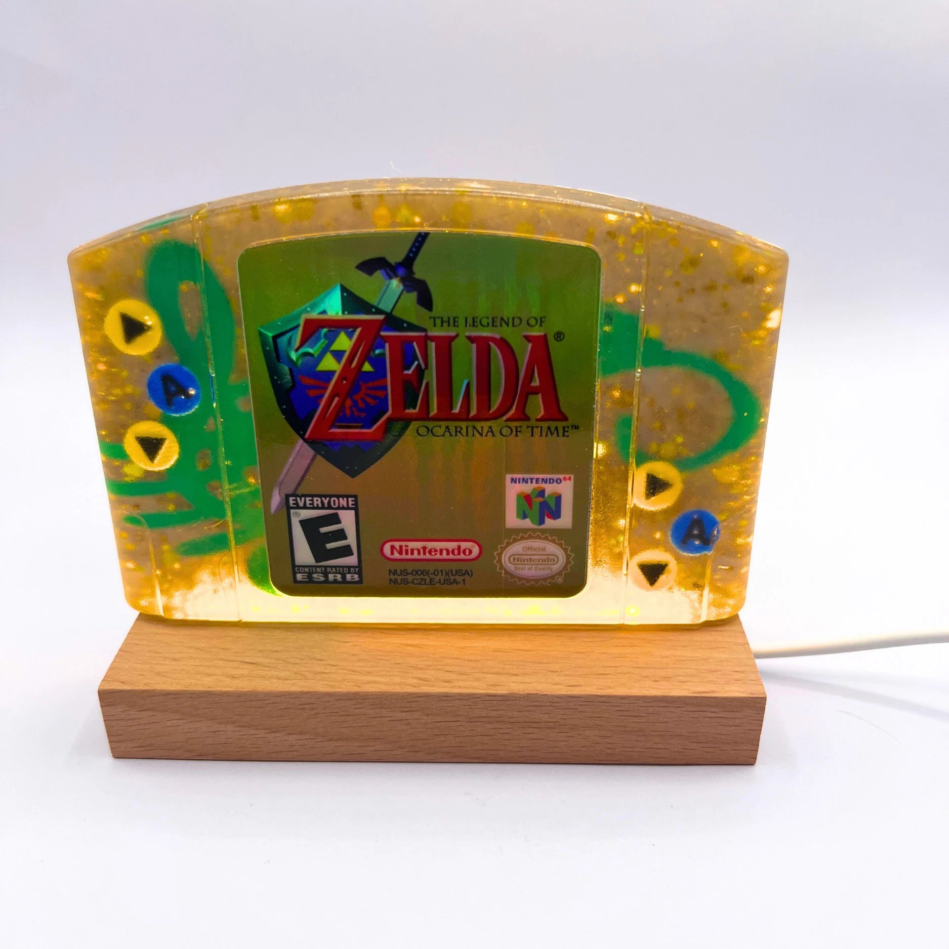 This handmade Zelda Ocarina of Time resin cartridge features vibrant custom art, adding a nostalgic touch for retro gaming fans. Ideal as a unique gift or display piece for collectors and gamers alike. 