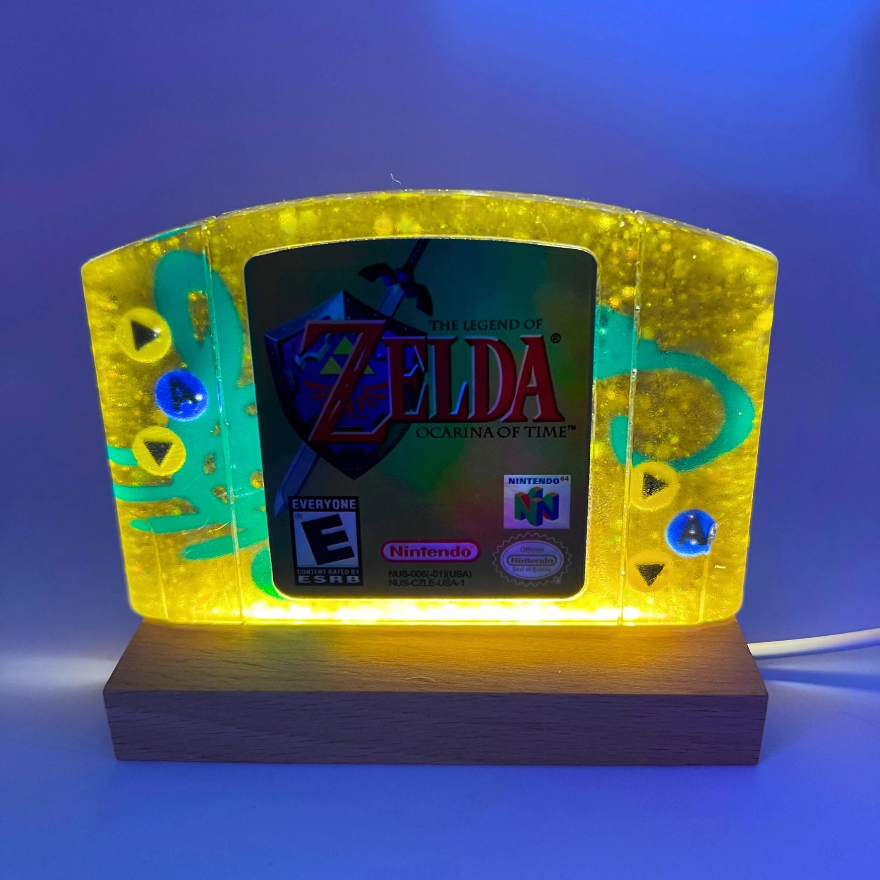 This handmade Zelda Ocarina of Time resin cartridge features vibrant custom art, adding a nostalgic touch for retro gaming fans. Ideal as a unique gift or display piece for collectors and gamers alike. 