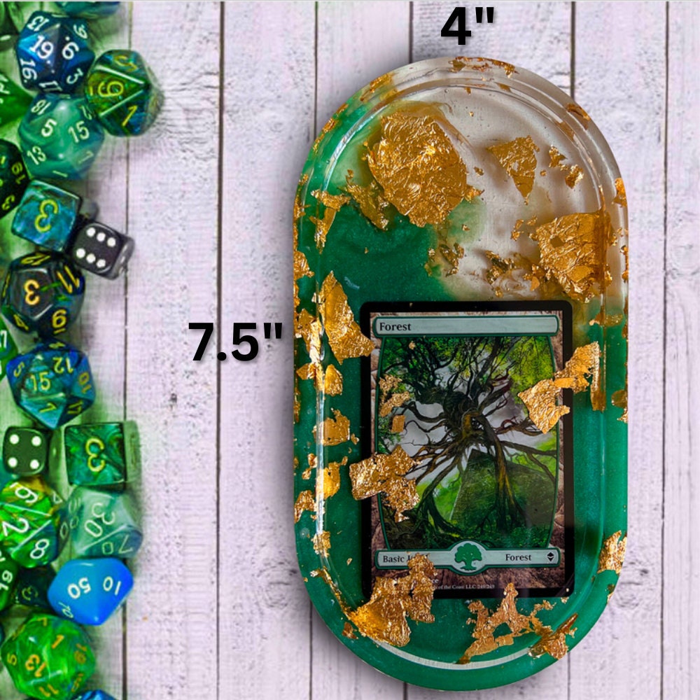 Handmade resin trinket tray featuring a Magic the Gathering Forest land design with green tones and gold foil accents. Perfect for dice, cards, or small items, ideal for gamers and collectors. Unique addition to any Magic the Gathering collection.