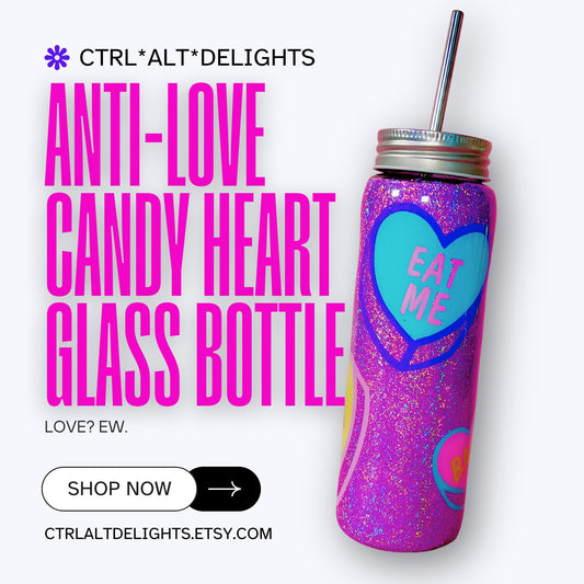 Handmade glitter tumbler with funny candy heart design in vibrant pink, blue, and purple colors. The tumbler features a shiny, sparkly finish and comes with a reusable metal straw. Perfect for adding a fun, quirky touch to your drinkware collection.