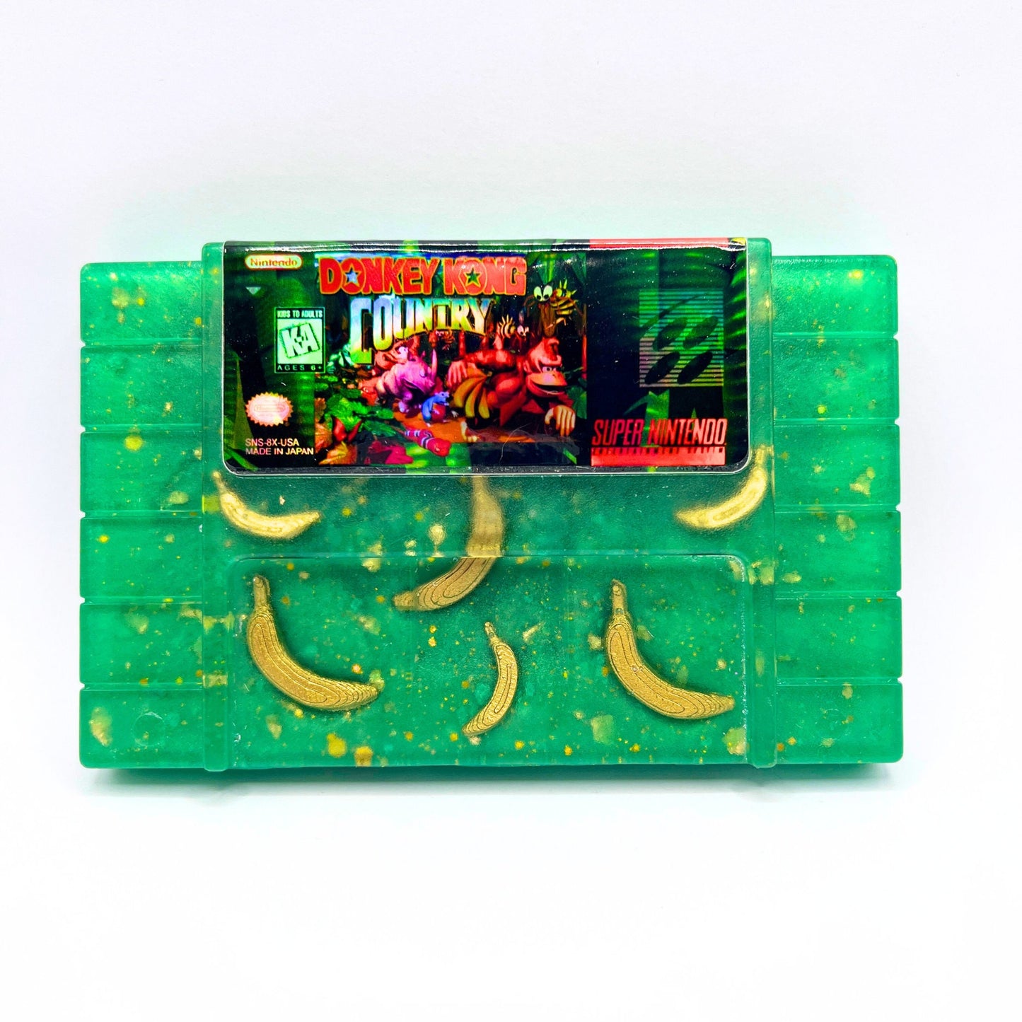 Retro Donkey Kong Country SNES cartridge art featuring embedded golden banana accents. Handmade and perfect for collectors or retro gaming fans seeking unique decor or gifts.