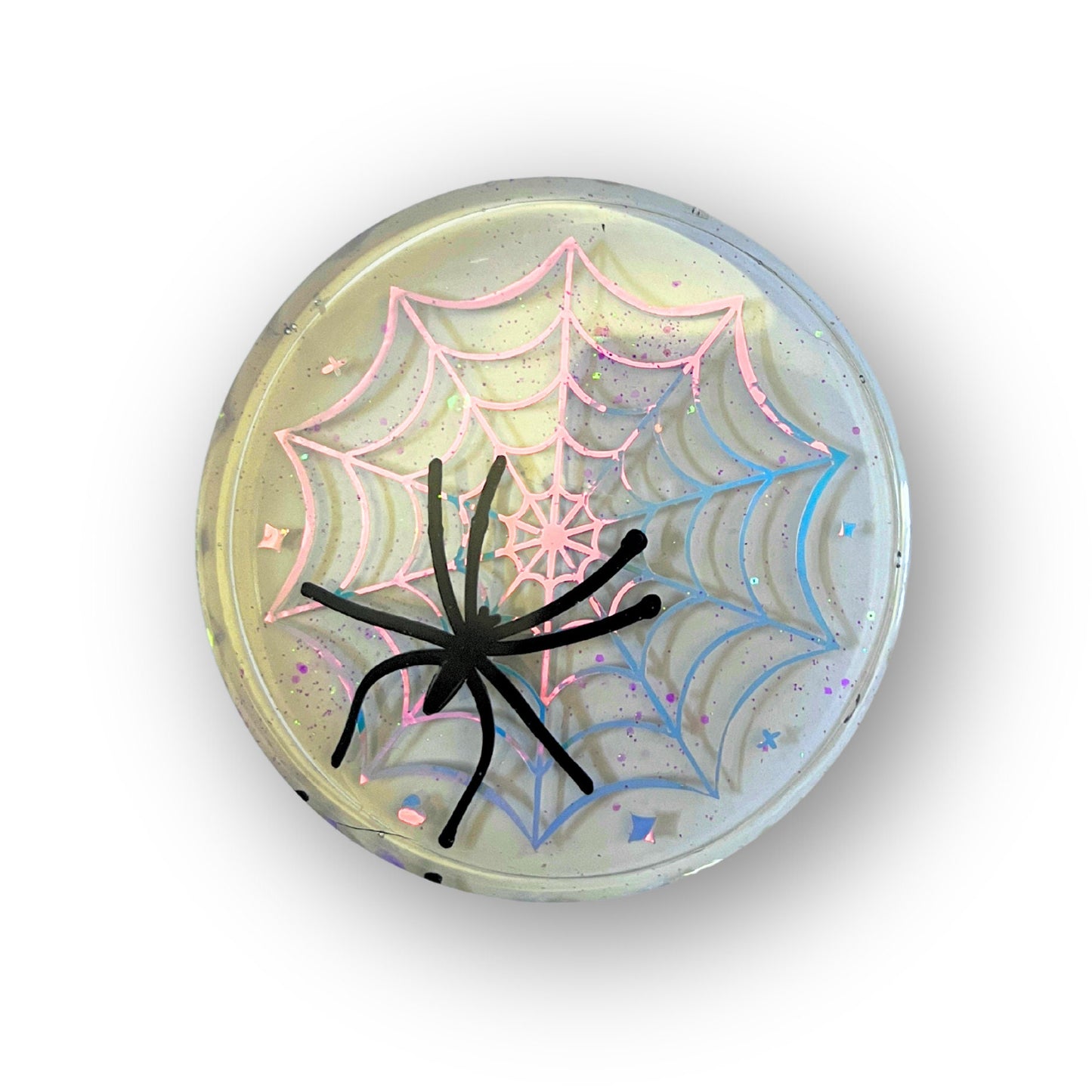 Pastel goth spiderweb coasters featuring a handmade resin design with intricate spiderwebs. Perfect for adding a dark, spooky aesthetic to any home. These unique coasters blend pastel colors with a goth twist, great for goth or Halloween-themed decor