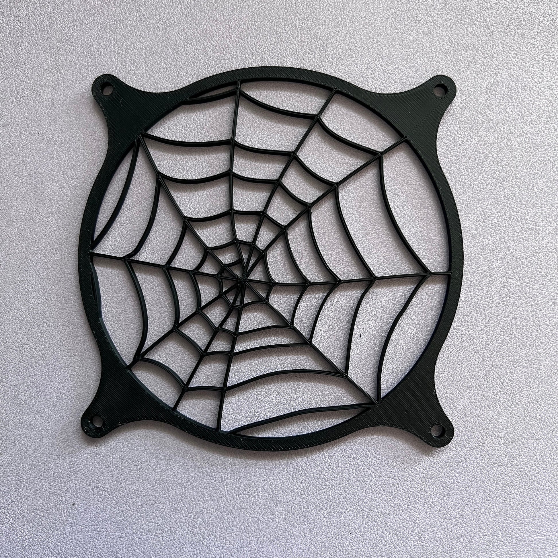 Spider web-themed decorative PC fan cover, 120mm grill for gaming setups. Custom 3D-printed design fits standard computer cases, adding a unique touch to your build. Available in Black or Black and white.