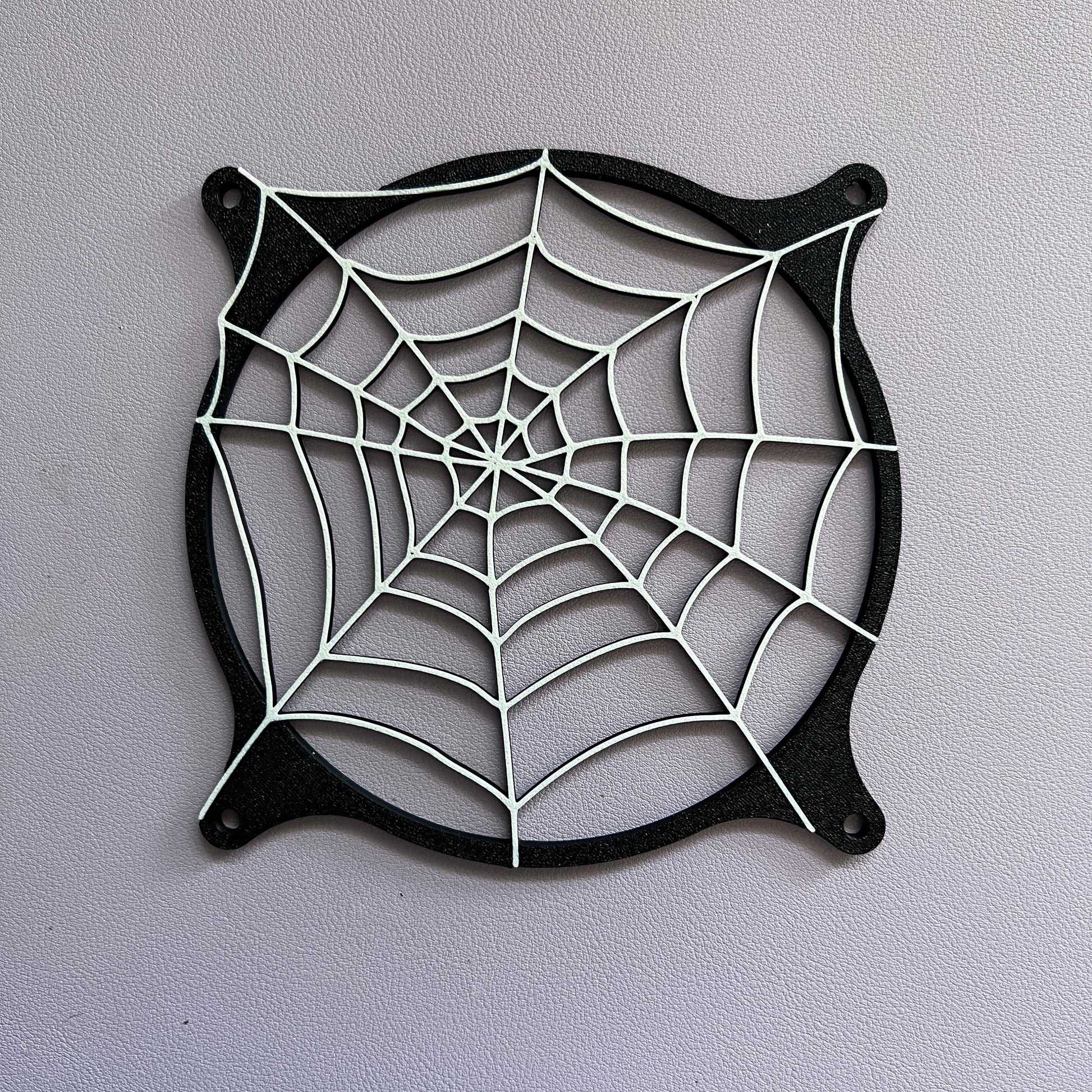 Spider web-themed decorative PC fan cover, 120mm grill for gaming setups. Custom 3D-printed design fits standard computer cases, adding a unique touch to your build. Available in Black or Black and white.