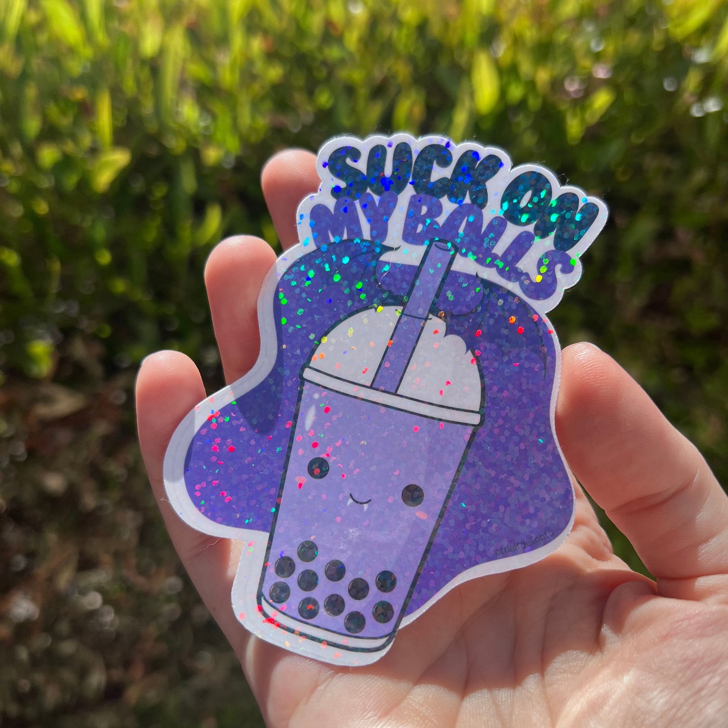 Holographic boba tea sticker with a cute bubble tea cup and the playful phrase Suck on My Balls in bold text. Perfect for decorating water bottles, laptops, and journals, this sassy and fun vinyl decal adds a quirky touch to your accessories.